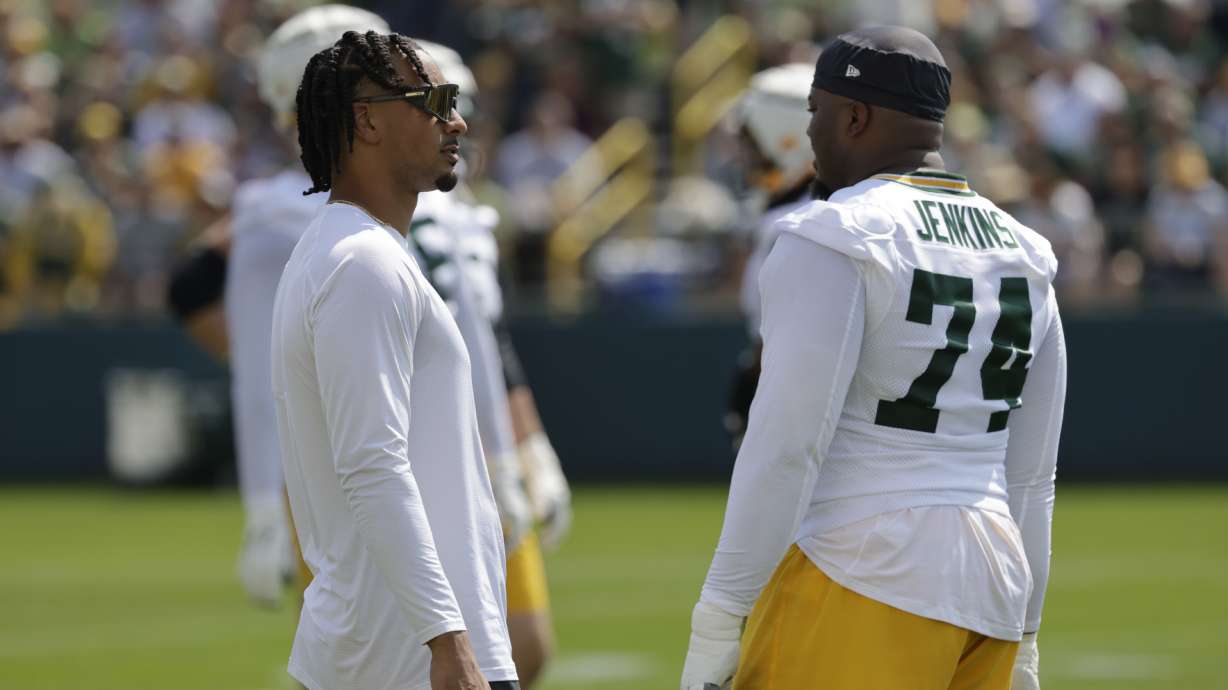 Green Bay Packers' Jordan Love, left, and Elgton Jenkins, right, talk during NFL football training camp Monday, July 22, 2024, in Green Bay, Wis.