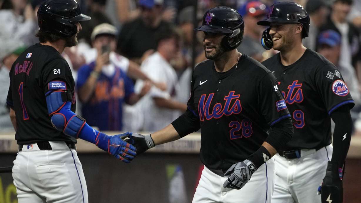 New York Mets' Jeff McNeil, left, J.D. Martinez, center, and Brandon Nimmo, right, celebrate after Martinez hit a grand slam also leading to Nimmo, Francisco Lindor and Tyrone Taylor to score during the third inning of a baseball game against the Atlanta Braves, Friday, July 26, 2024, in New York.