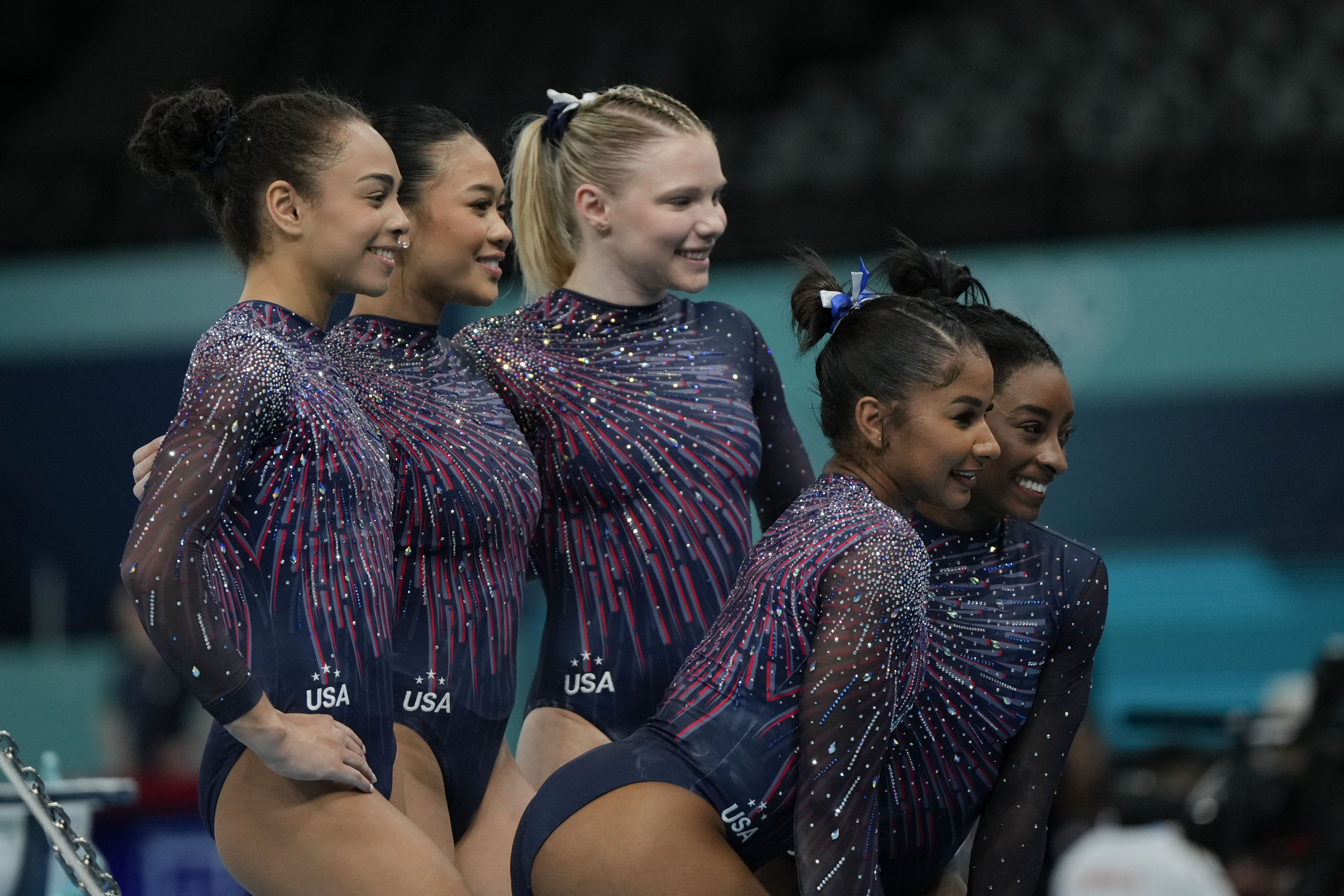 The United States team from left to right, Hezly Rivera, Suni Lee, Jade Carey, Jordan Chiles and Simone Biles pose for a picture during a gymnastics training session at Bercy Arena at the 2024 Summer Olympics, Thursday, July 25, 2024, in Paris, France. 