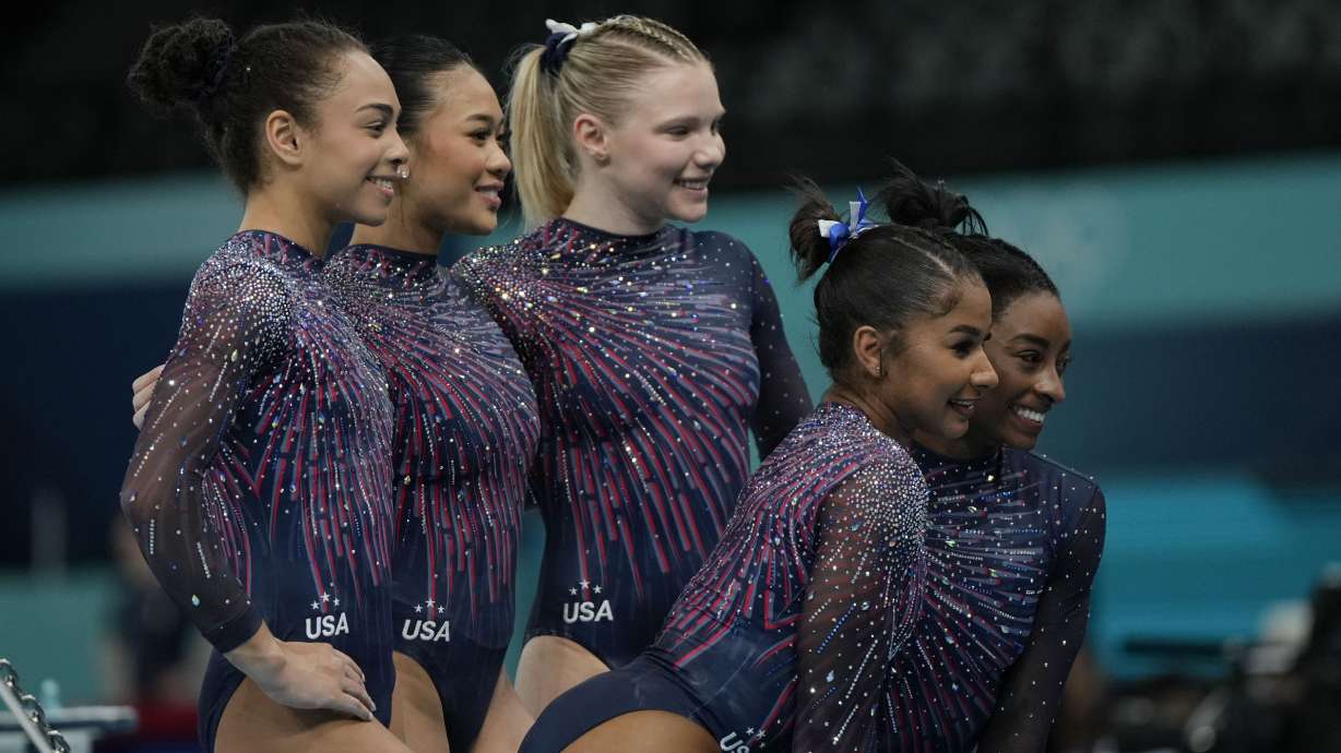 The United States team from left to right, Hezly Rivera, Suni Lee, Jade Carey, Jordan Chiles and Simone Biles pose for a picture during a gymnastics training session at Bercy Arena at the 2024 Summer Olympics, Thursday, July 25, 2024, in Paris, France.