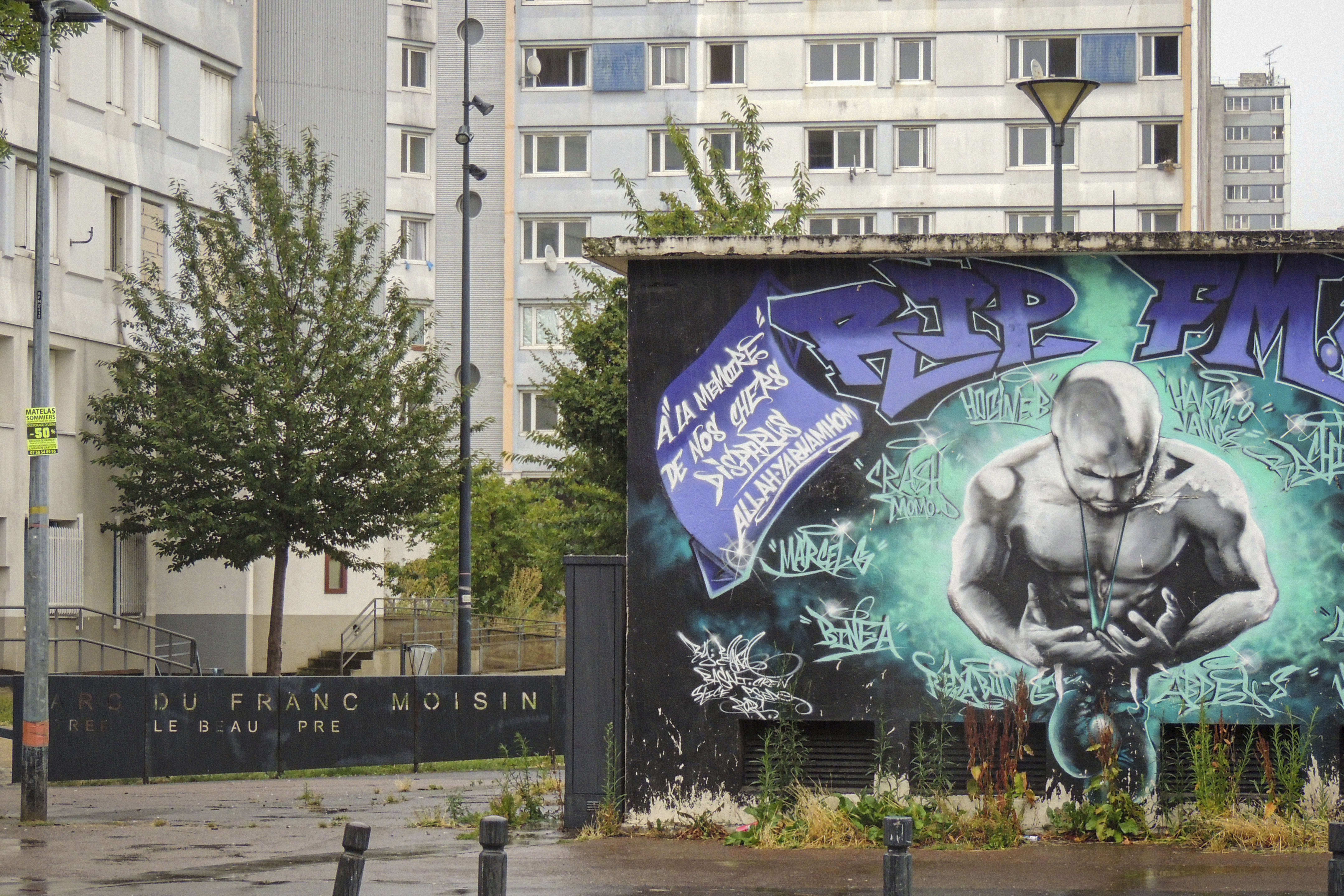Buildings and graffitis are pictures during the opening ceremony of the 2024 Summer Olympics, Friday, July 26, 2024 in the Franc-Moisin housing project in Saint-Denis, outside Paris. Residents of one Paris neighborhood say they passed on the opening ceremony after being overlooked. For many in Saint-Denis, the Olympics feel like a distant spectacle. 