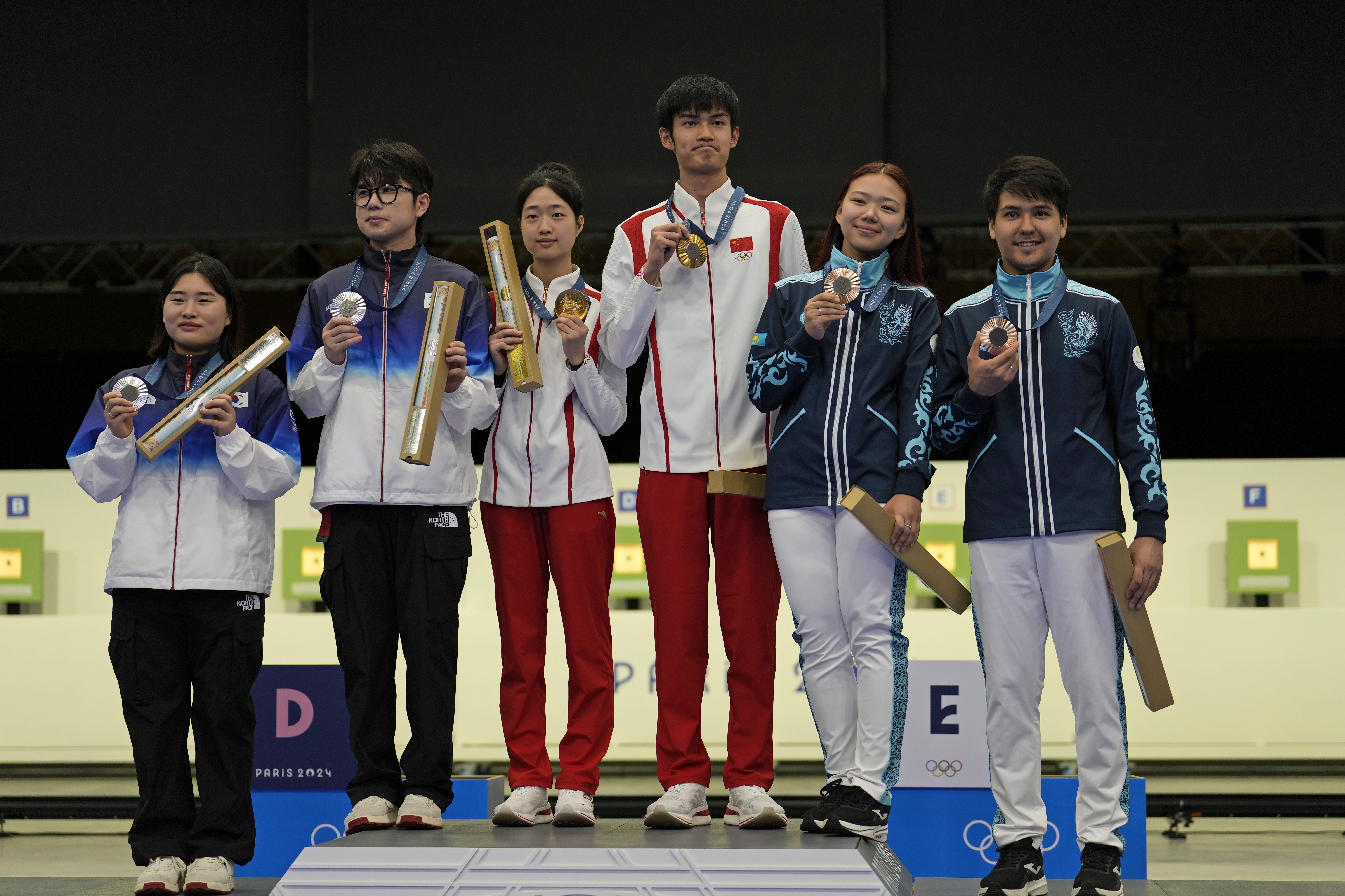 Medal winners pose for a photograph after the medal ceremony of the 10m air rifle mixed team competition at the 2024 Summer Olympics, Saturday, July 27, 2024, in Chateauroux, France. China's Sheng Lihao and Huang Yuting won the gold in the competion, while South Korea's Park Hajun and Keum Jihyeon took silver and Kazakhstan's Islam Satpayev and Alexandra Le took the bronze.