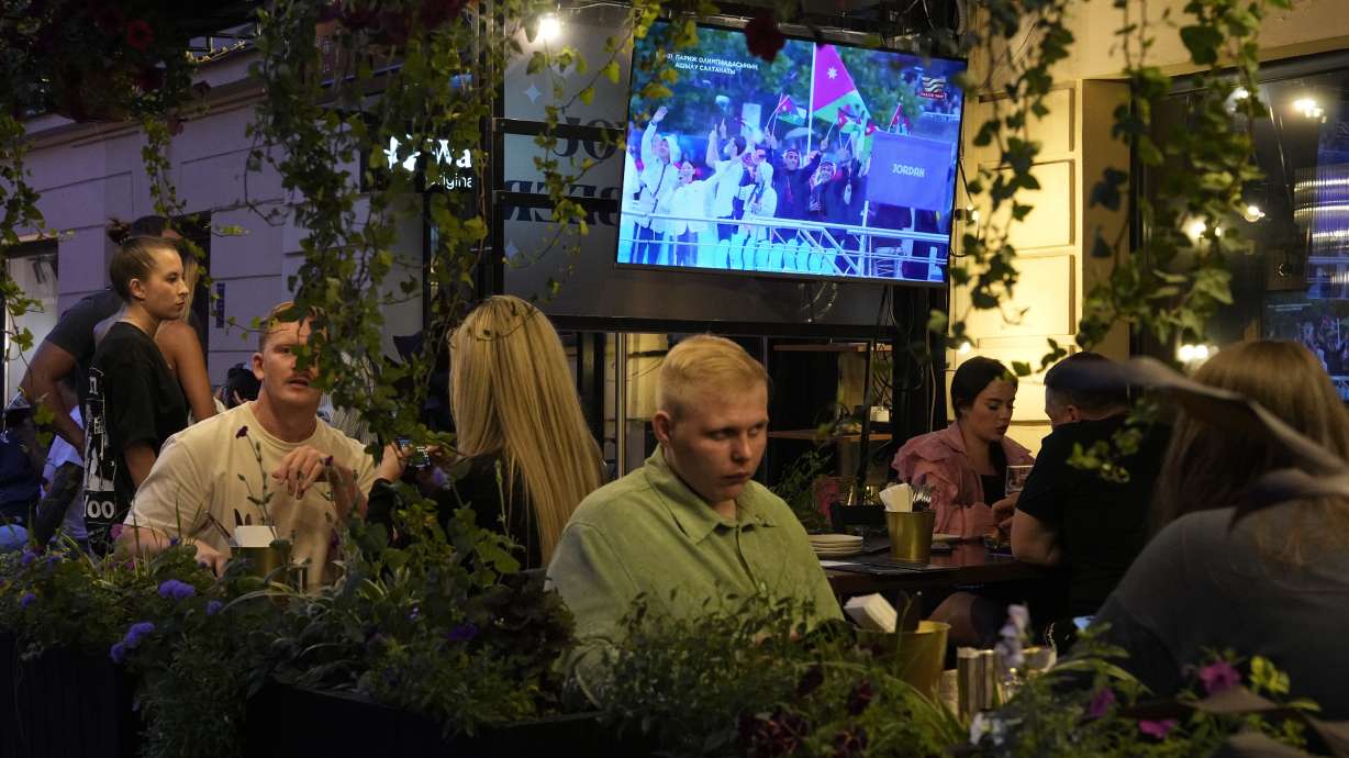 People watch the television broadcast of the opening ceremony of the 2024 Summer Olympics in Paris, France via Kazakhstan satellite channel sitting in the Waterloo pub & bar in St. Petersburg, Russia, Friday, July 26, 2024. Watching the Paris Olympics will be difficult for most people in Russia, and in the view of local media it's not really worth the effort. Russia's state TV channels won't be broadcasting any of the events.