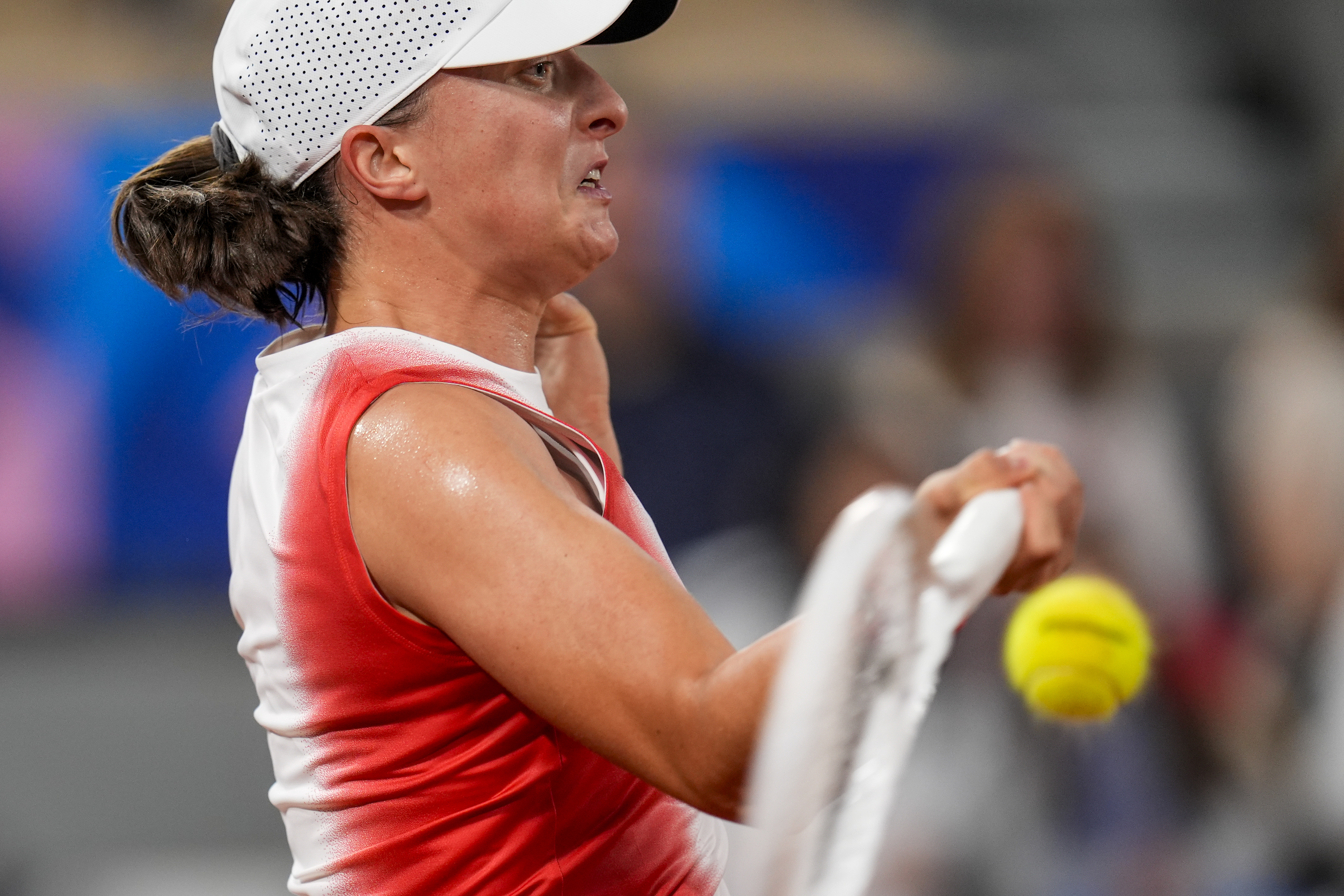 Iga Swiatek of Poland returns the ball against Irina-Camelia Begu of Romani during a women's singles tennis competition, at the 2024 Summer Olympics, Saturday, July 27, 2024, in Paris, France. 