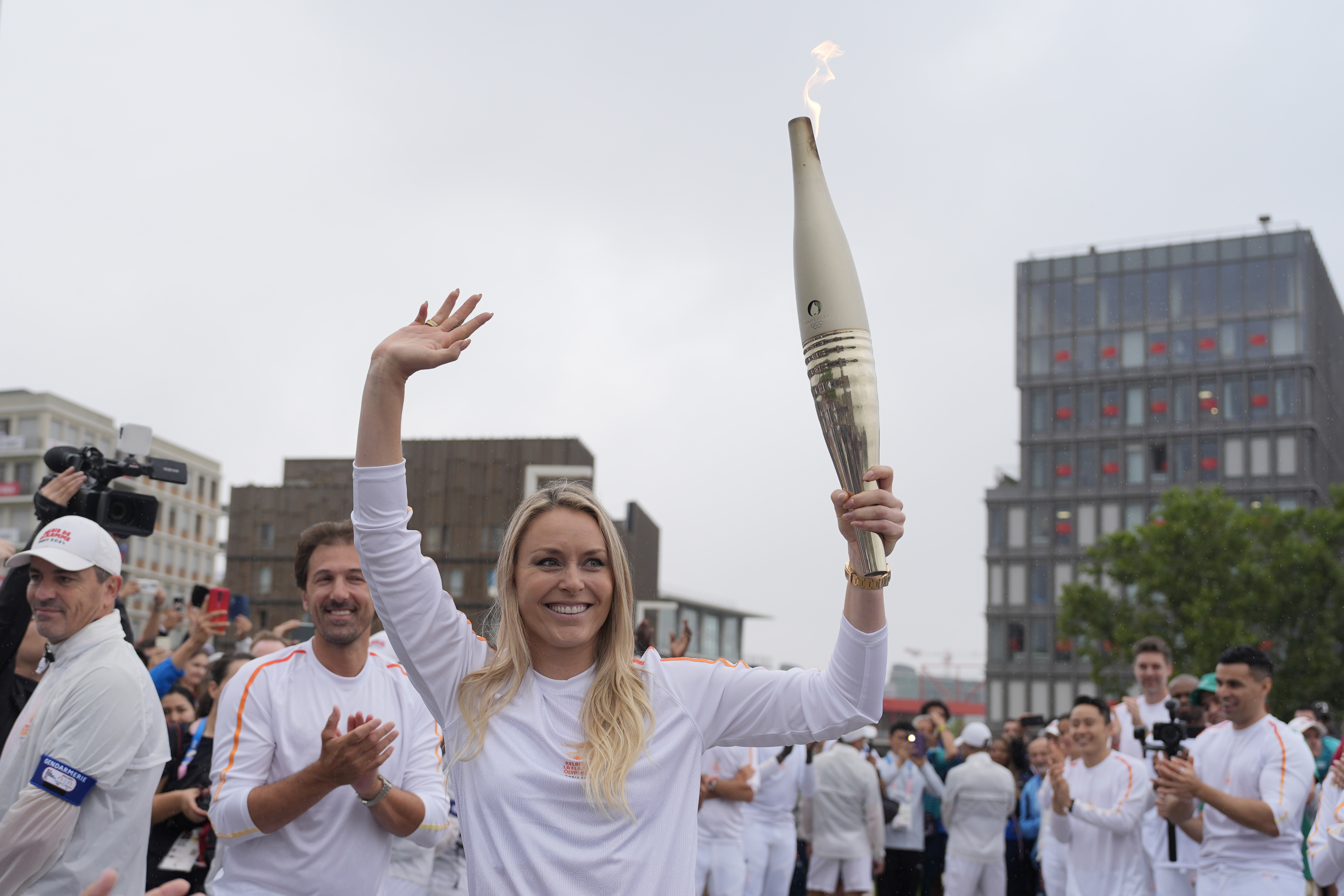 Former US skier Lindsey Vonn carries the Olympic torch in the Olympic village at the 2024 Summer Olympics, Friday, July 26, 2024, in Paris, France. 