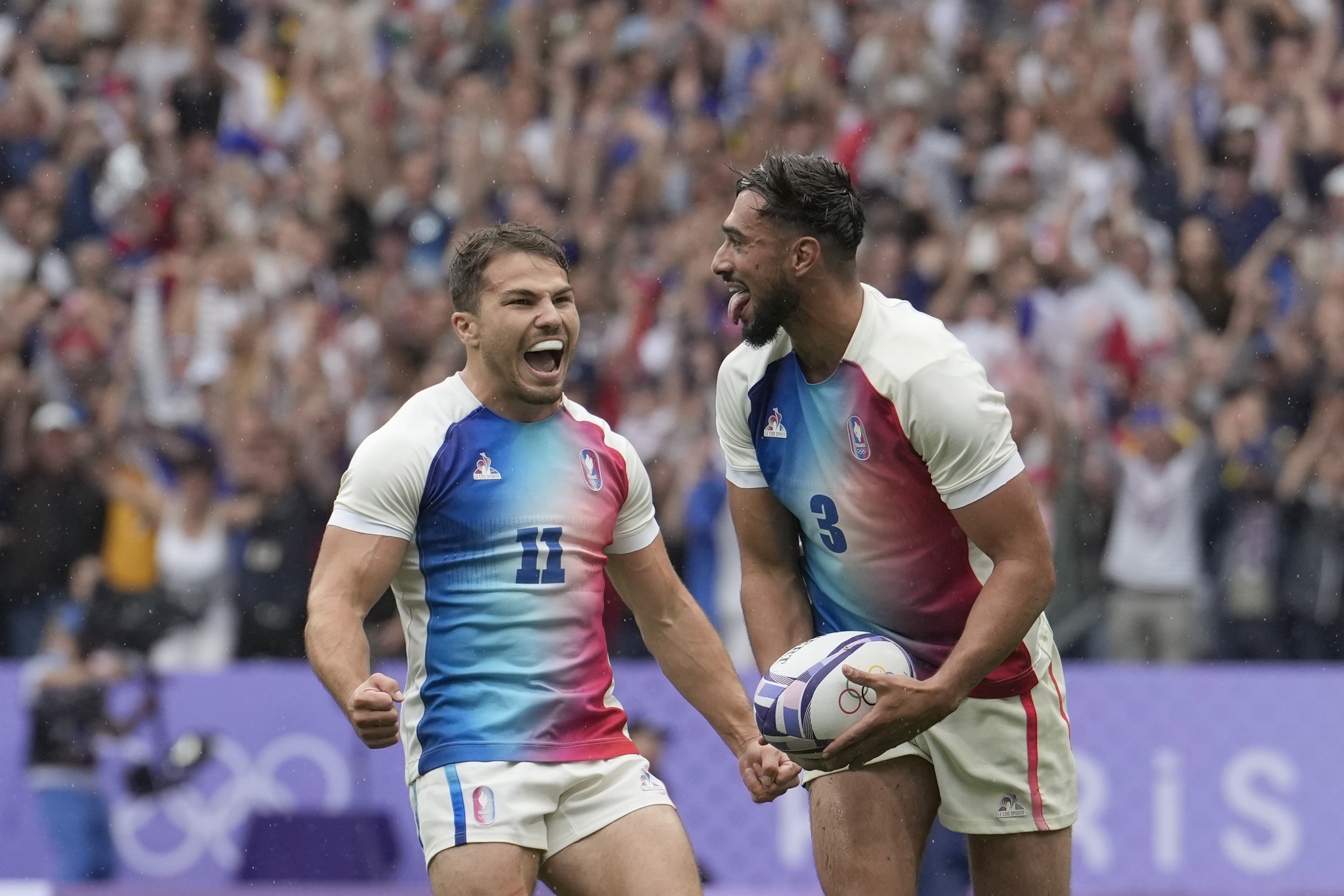 Rayan Rebbadj of France, right, celebrates after scoring a try with teammate Antoine Dupont of France during the men's semifinal Rugby Sevens match between South Africa and France at the 2024 Summer Olympics, in the Stade de France, in Saint-Denis, France, Saturday, July 27, 2024. 