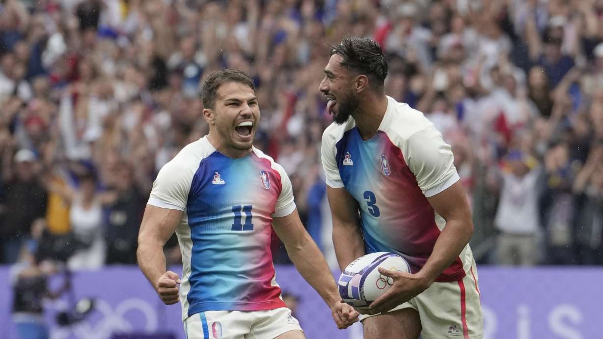 Rayan Rebbadj of France, right, celebrates after scoring a try with teammate Antoine Dupont of France during the men's semifinal Rugby Sevens match between South Africa and France at the 2024 Summer Olympics, in the Stade de France, in Saint-Denis, France, Saturday, July 27, 2024.