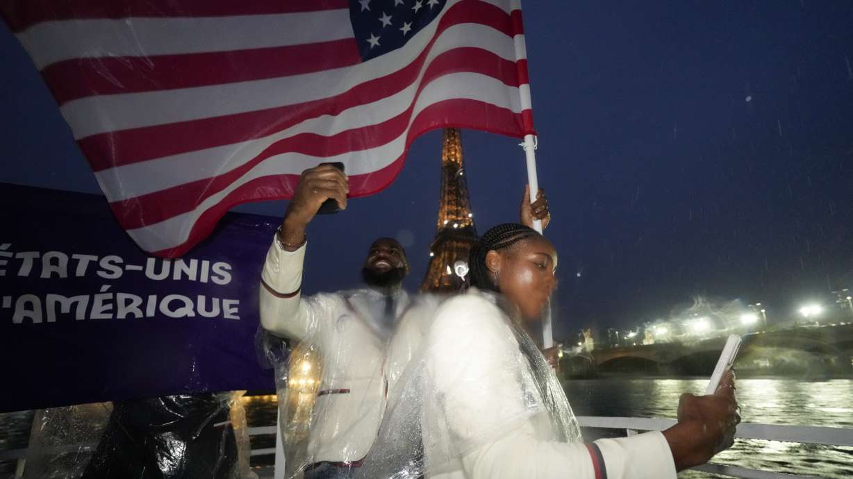 United States' Coco Gauff and Lebron James take photos as they travel along the Seine River in Paris, France, during the opening ceremony of the 2024 Summer Olympics, Friday, July 26, 2024.