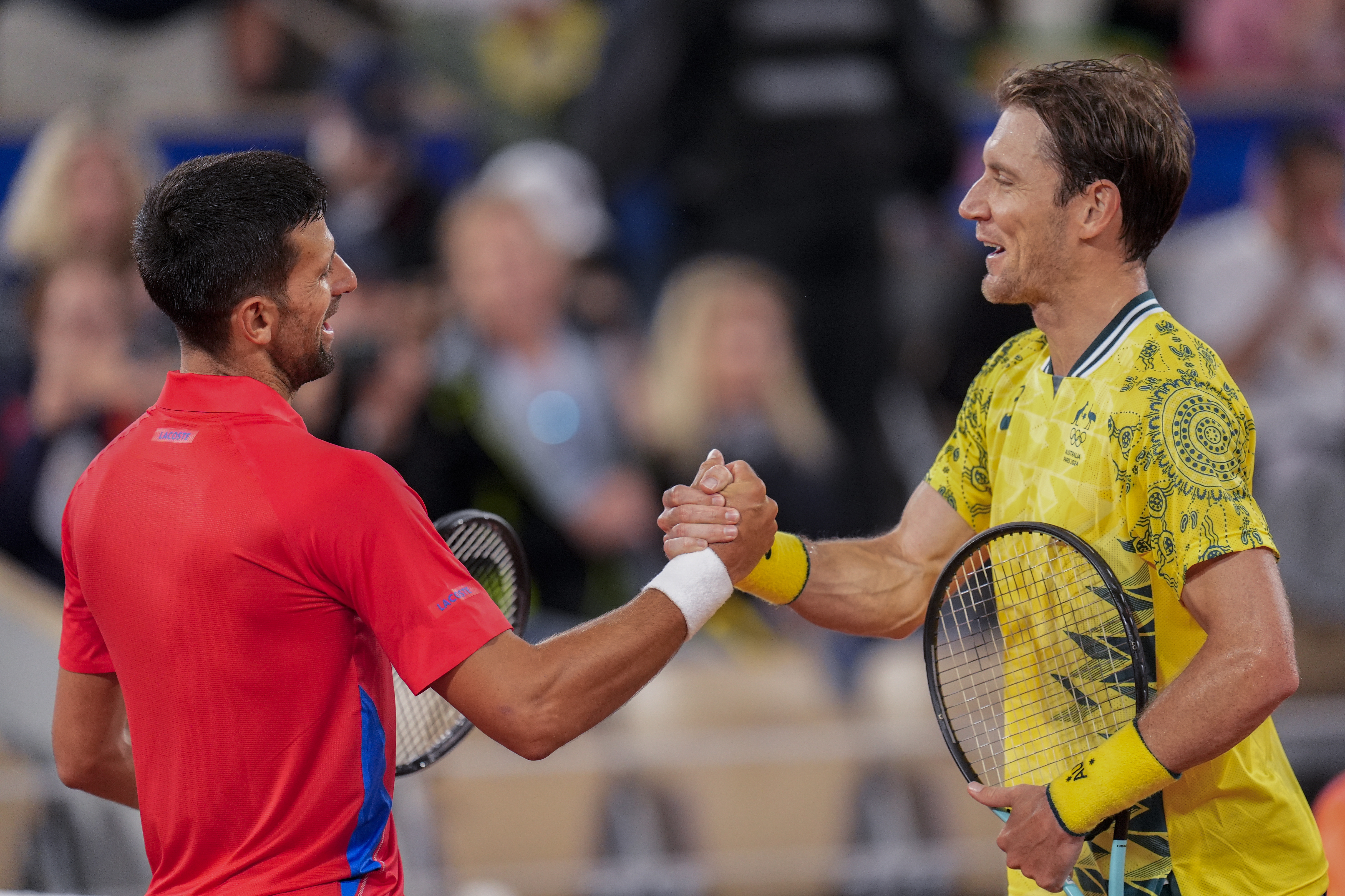 Serbian tennis player Novak Djokovic shakes hands with Matthew Ebden of Australia at the end of the men's singles tennis competition, at the 2024 Summer Olympics, Saturday, July 27, 2024, in Paris, France.