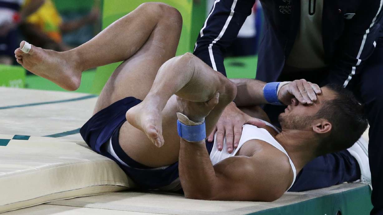 FILE - France's Samir Ait Said holds his leg after injuring it while performing on the vault during the artistic gymnastics men's qualification at the 2016 Summer Olympics in Rio de Janeiro, Brazil, Aug. 6, 2016.