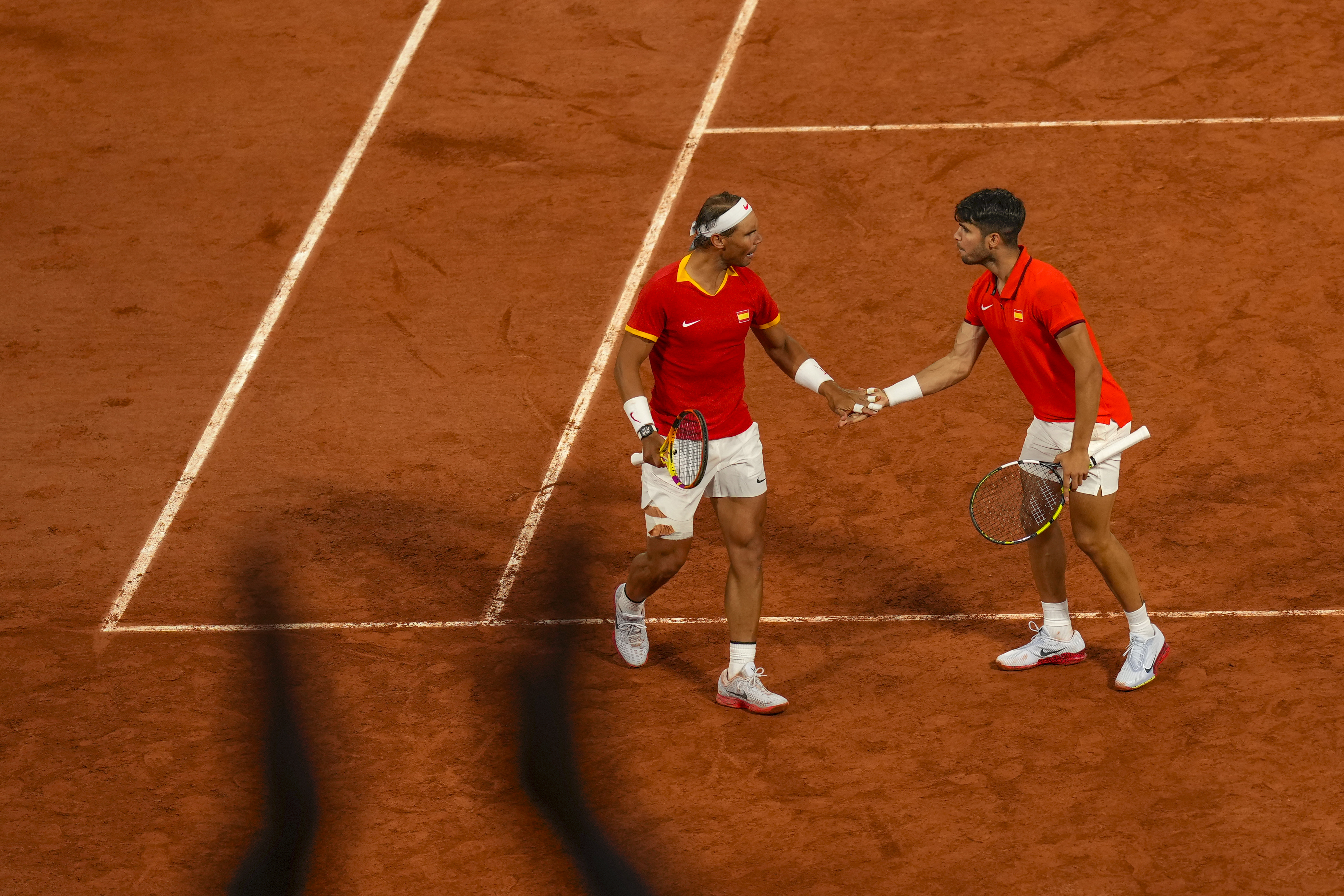 Carlos Alcaraz, left, and Rafael Nadal from the Spanish team celebrate a point during the men's doubles tennis competition against Andres Molteni and Maximo Gonzalez from the Argentina team, at the 2024 Summer Olympics, Saturday, July 27, 2024, in Paris, France.