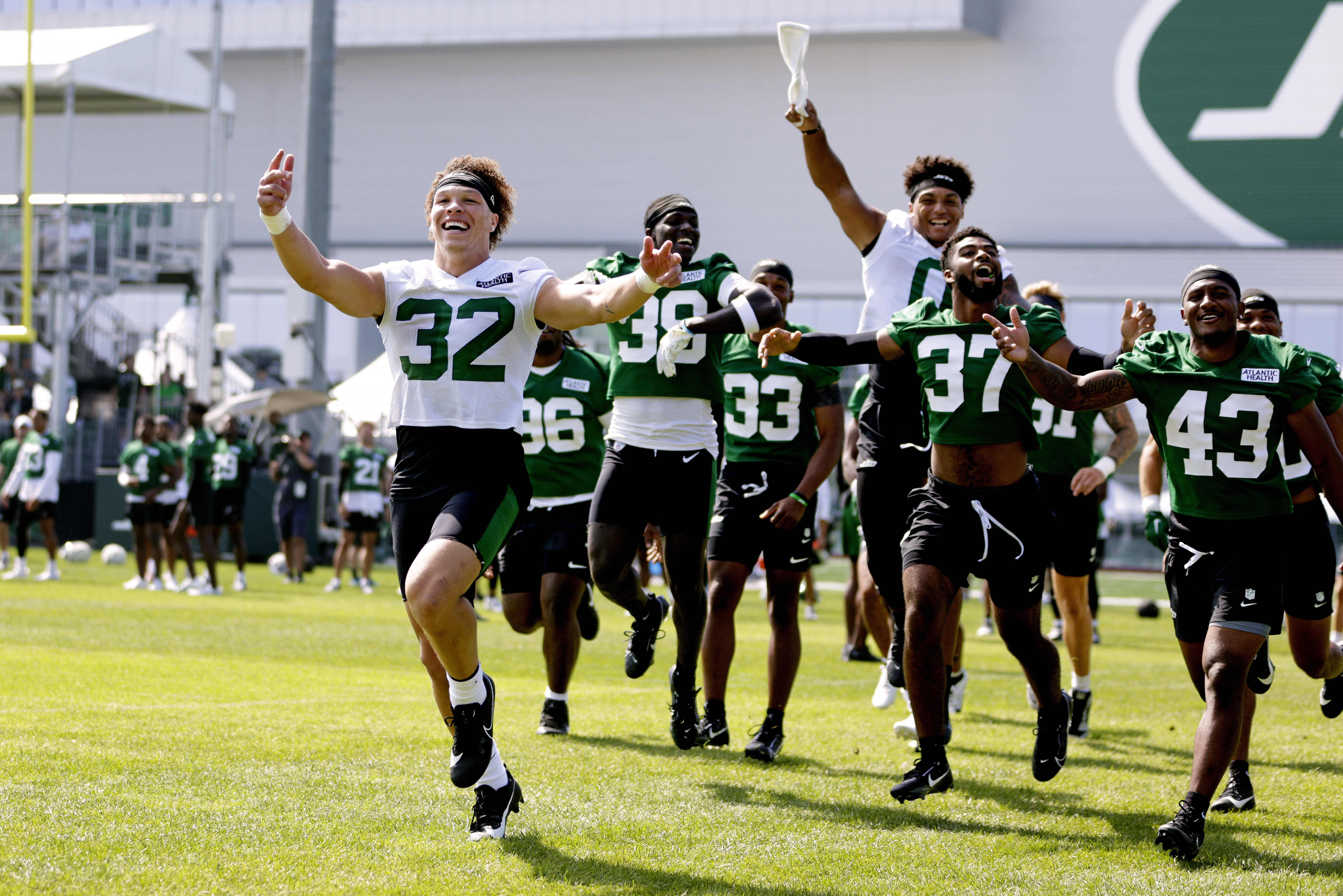 New York Jets running back Isaiah Davis (32) and teammates pump up the fans before the start of the team's NFL football training camp, Saturday, July 27, 2024, in Florham Park, N.J. 