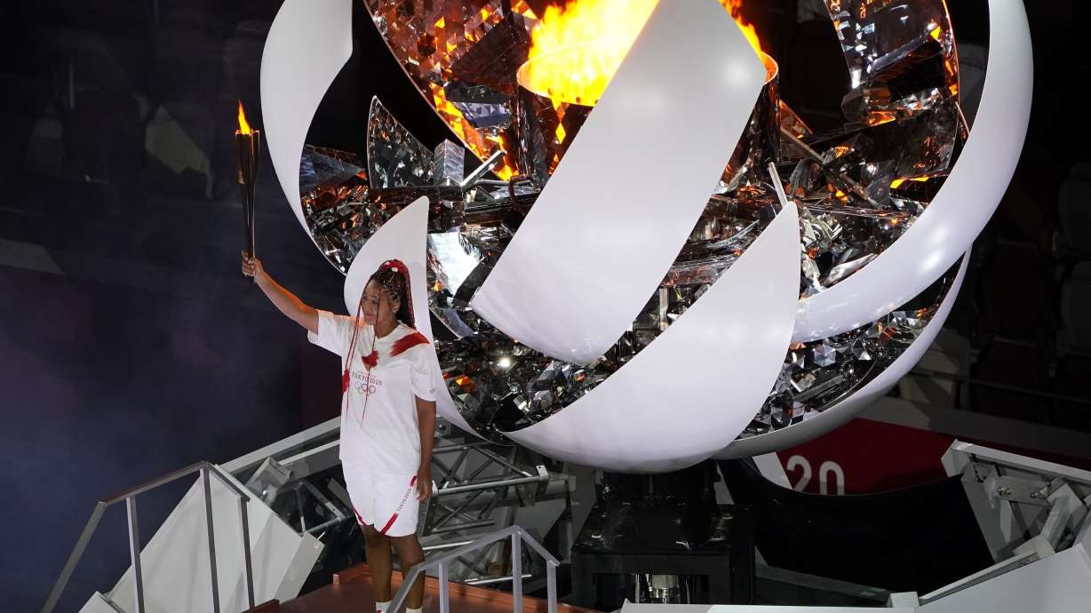 FILE - Naomi Osaka lights the Olympic cauldron during the opening ceremony at the Olympic Stadium at the 2020 Summer Olympics, July 23, 2021, in Tokyo.