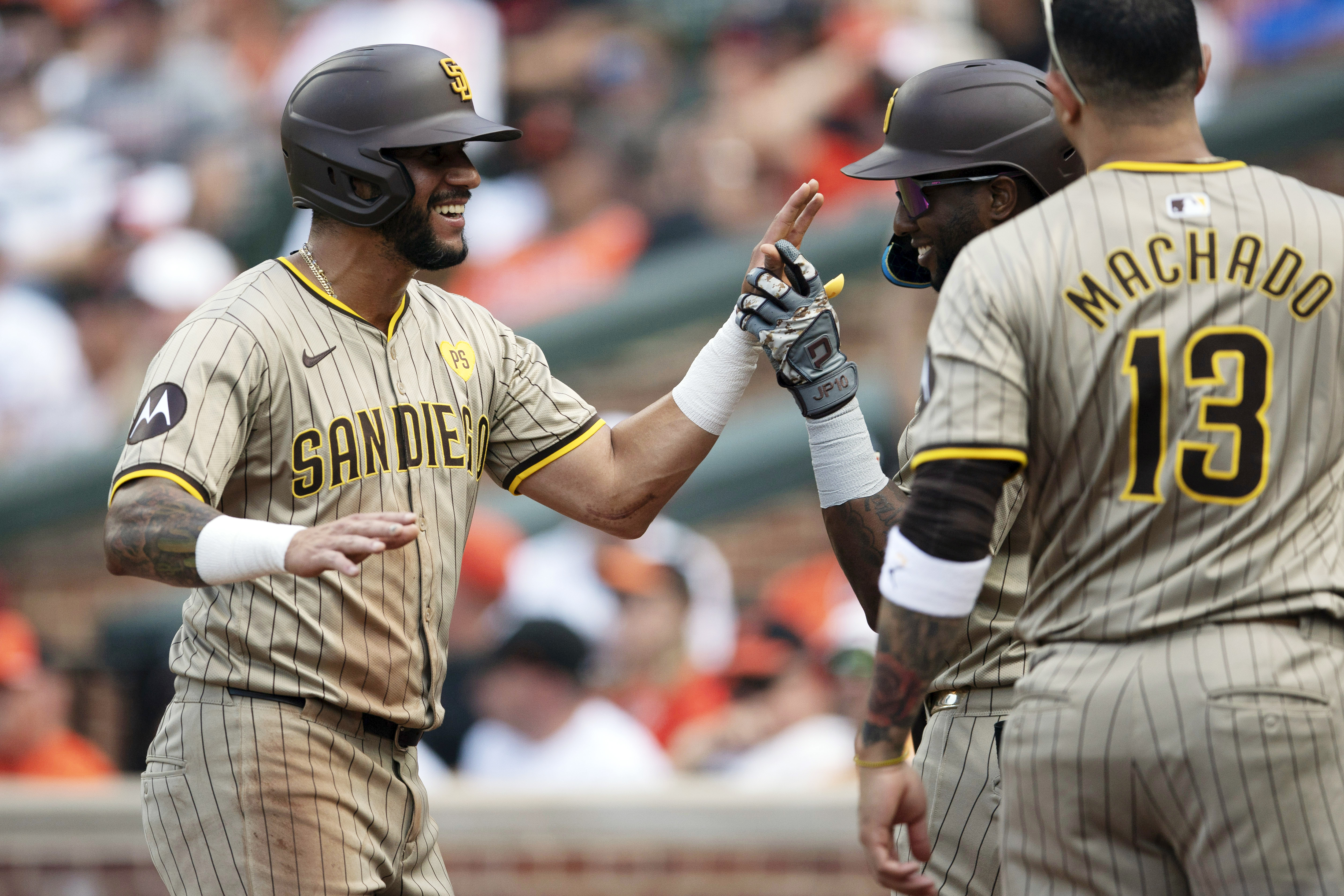San Diego Padres first base Luis Arraez, left, celebrates with his teammates after scoring in the second inning of a baseball game against Baltimore Orioles, Saturday, July 27, 2024, in Baltimore. 