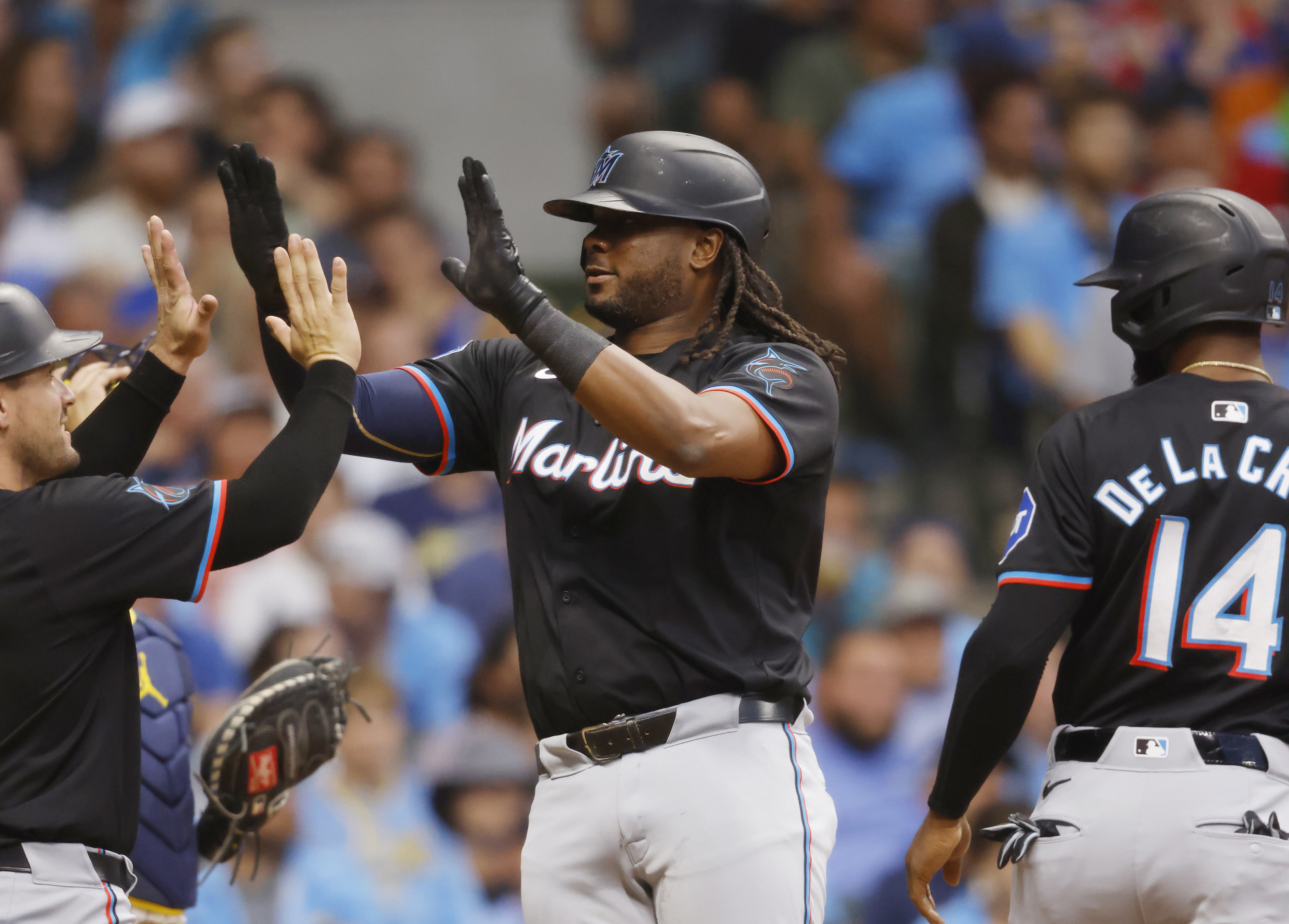Miami Marlins' Josh Bell, center, is congratulated by Nick Fortes, left, after hitting a three-run home run during the seventh inning of a baseball game against the Milwaukee Brewers, Saturday, July 27, 2024, in Milwaukee. 