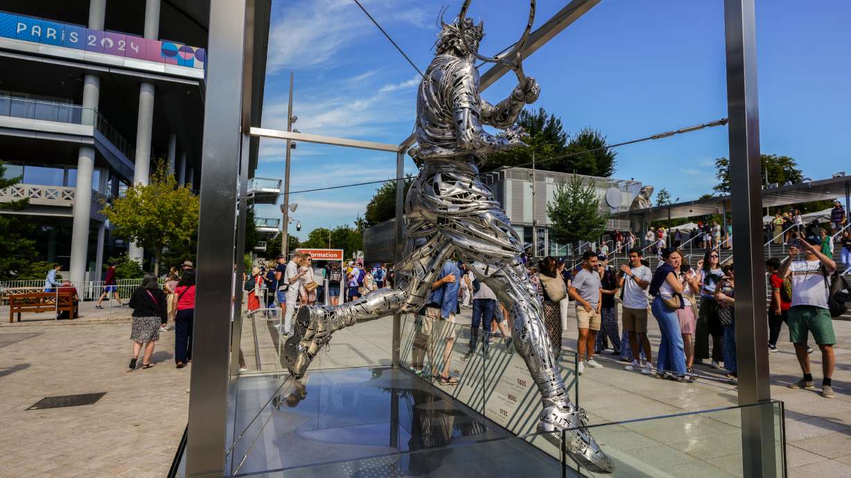 People gather next to the statue of Spanish artist Jordi Diez representing Spain's Rafael Nadal at the Roland Garros stadium during the 2024 Summer Olympics, Sunday, July 28, 2024, in Paris, France.
