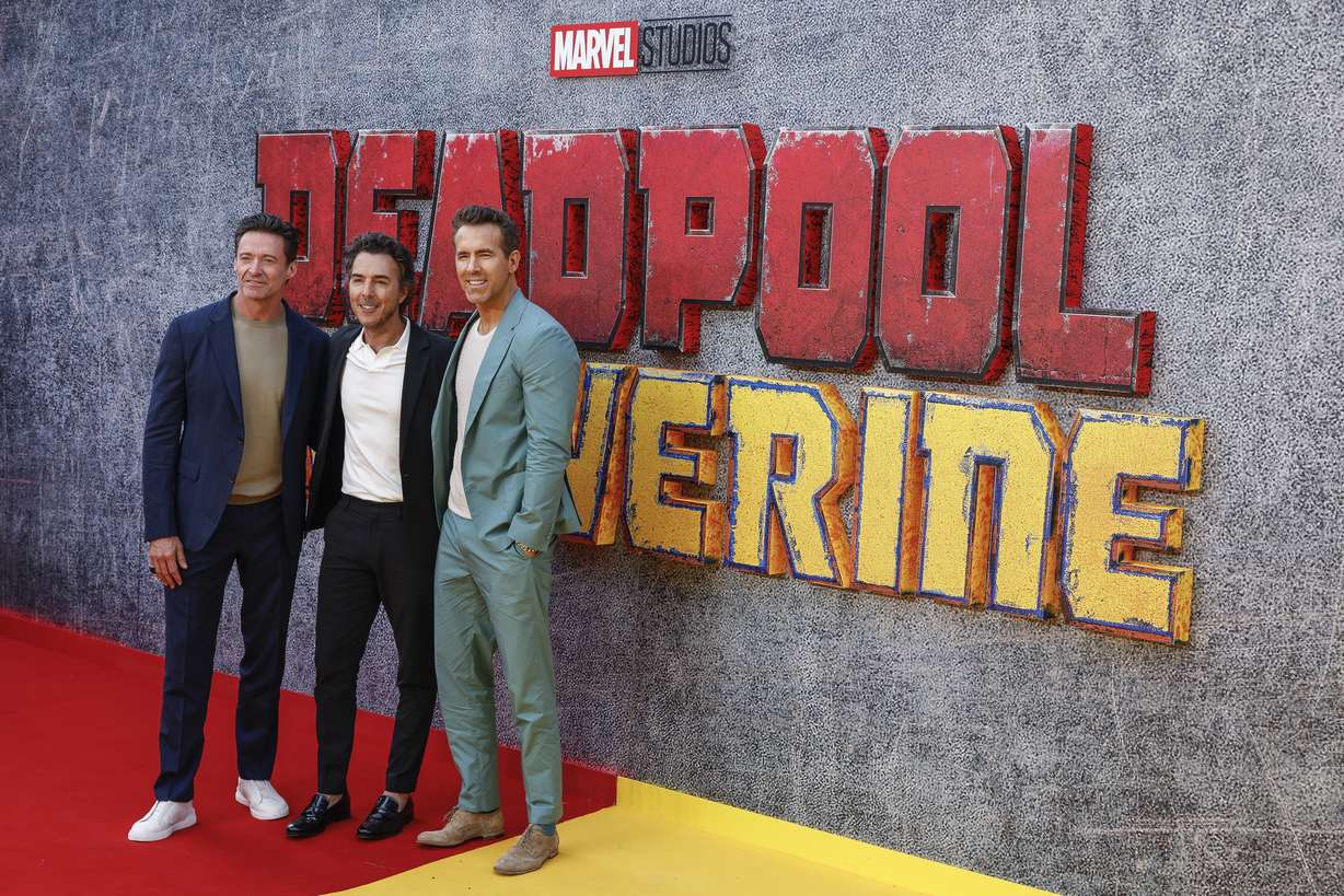 Hugh Jackman, left, director Shawn Levy and Ryan Reynolds pose for photographers upon arrival at the screening of the film 'Deadpool & Wolverine' on Thursday, July 11, 2024 in London.
