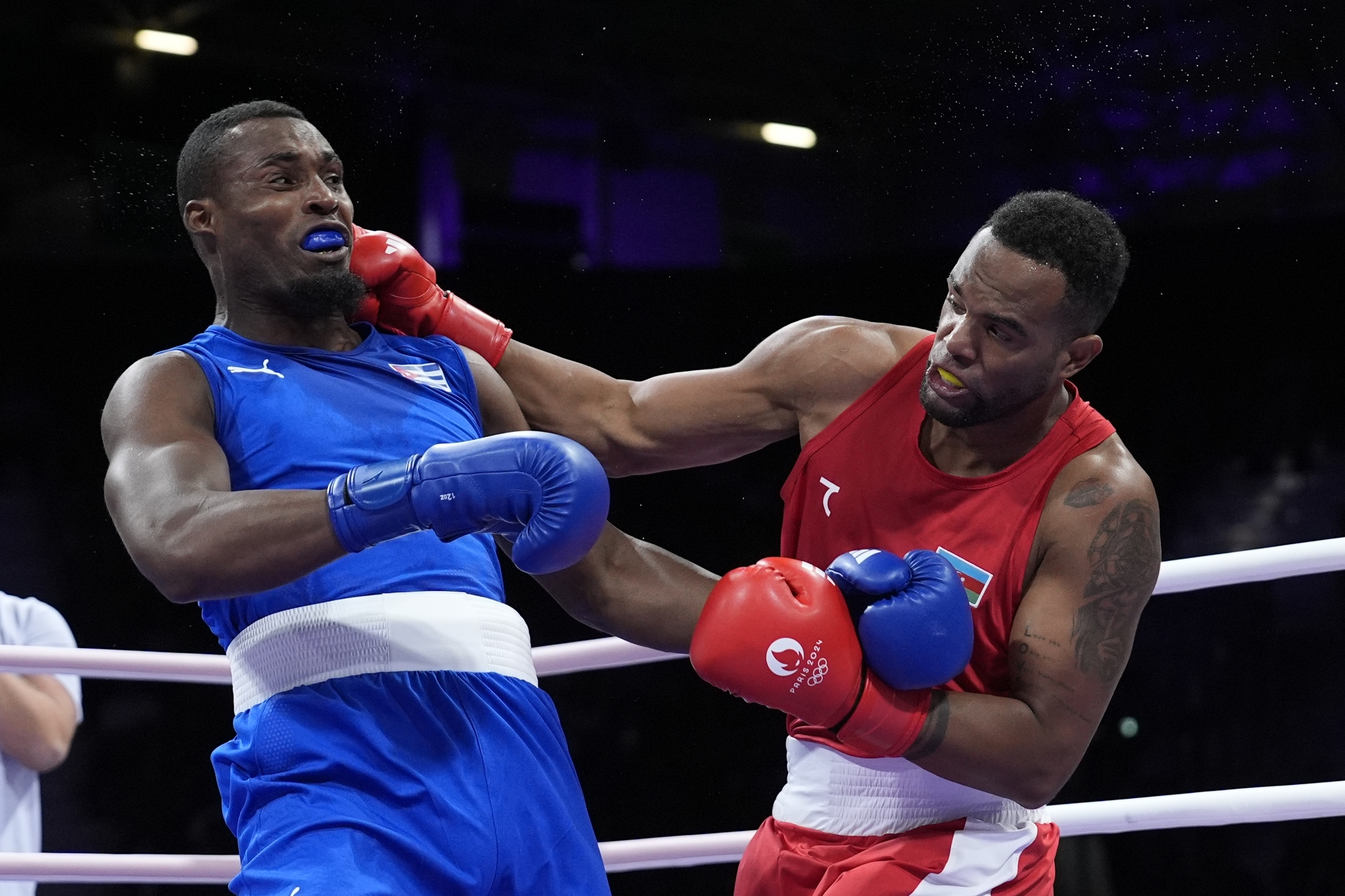 Azerbaijan's Loren Alfonso, right, fights Cuba's Julio La Cruz Peraza, left, in their men's 92 kg preliminary boxing matchat the 2024 Summer Olympics, Sunday, July 28, 2024, in Paris, France. 