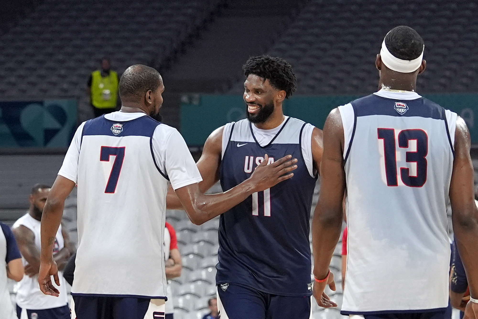 United State's Kevin Durant, left, pats Joel Embiid, center, after practice as Bam Adebayo watches during men's basketball practice at the 2024 Summer Olympics, Wednesday, July 24, 2024, in Villeneuve-d'Ascq, France. 