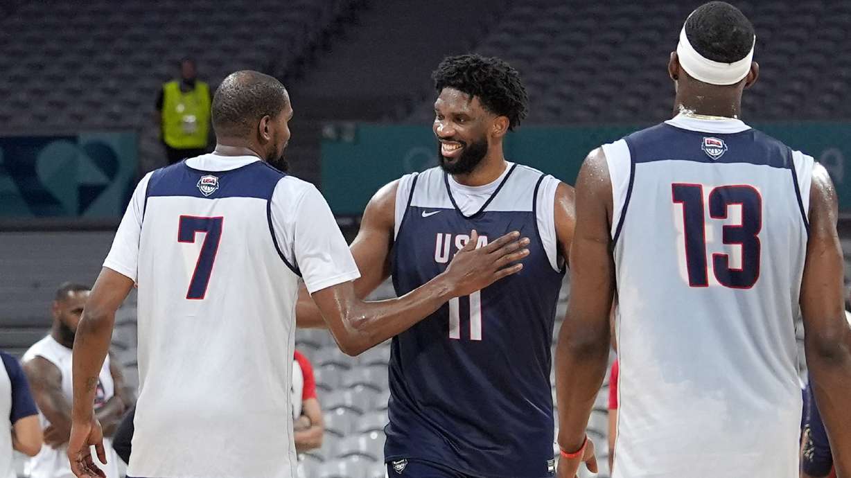 United State's Kevin Durant, left, pats Joel Embiid, center, after practice as Bam Adebayo watches during men's basketball practice at the 2024 Summer Olympics, Wednesday, July 24, 2024, in Villeneuve-d'Ascq, France.