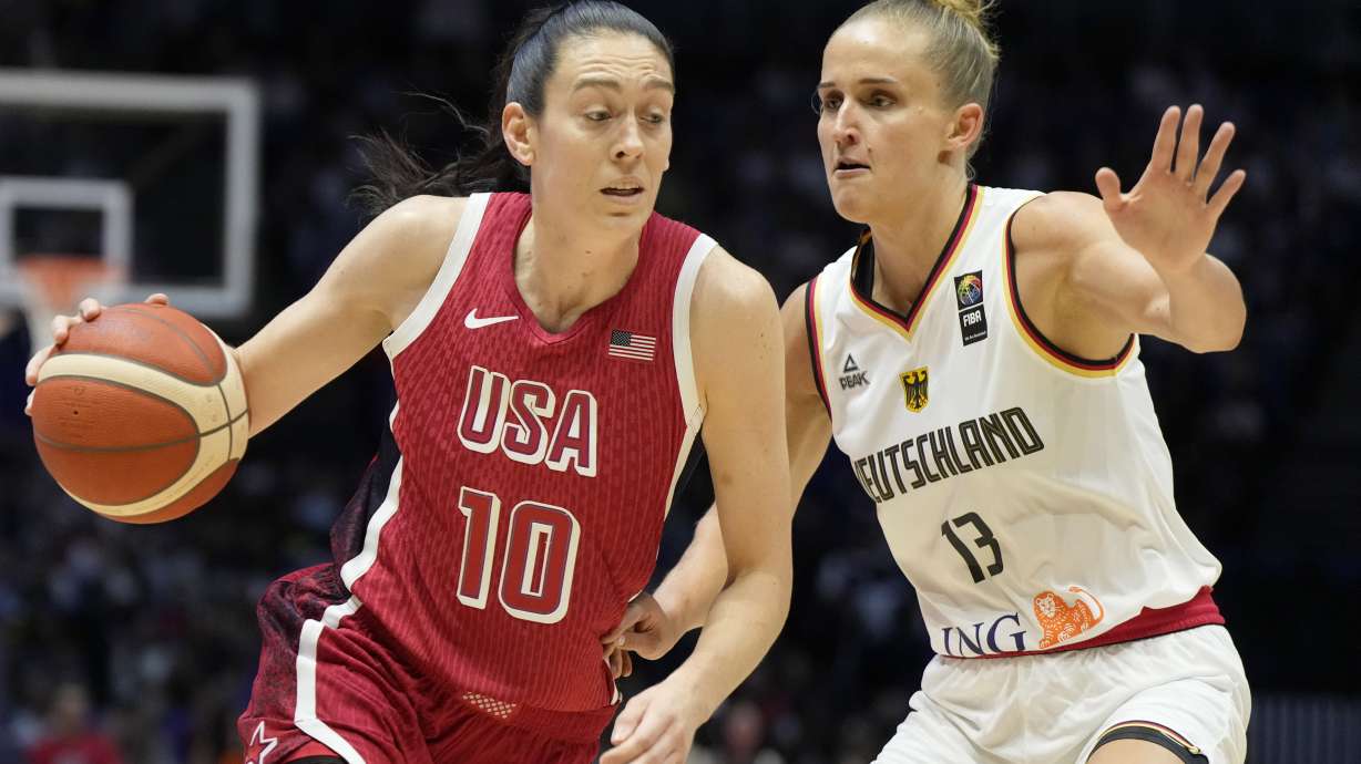 United States' Breanna Stewart, left, drives around Germany's Leonie Fiebich during a women's exhibition basketball game between the United States and Germany at the O2 Arena in London, Tuesday, July 23, 2024.
