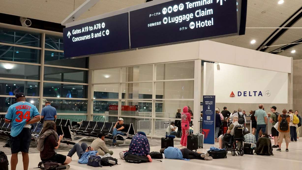 Travelers wait in a long line to speak with a Delta representative at the help desk in the McNamara terminal at the Detroit Metropolitan Wayne County Airport on July 20.
