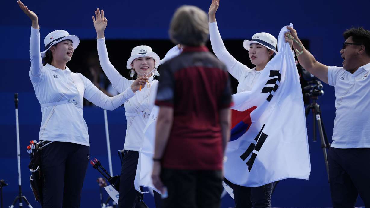 South Korea's Lim Si-hyeon, center, Jeon Hun-young, left, and Nam Su-hyeon, right, celebrate a win against China during the Archery women's team gold medal match at the 2024 Summer Olympics, Sunday, July 28, 2024, in Paris, France.
