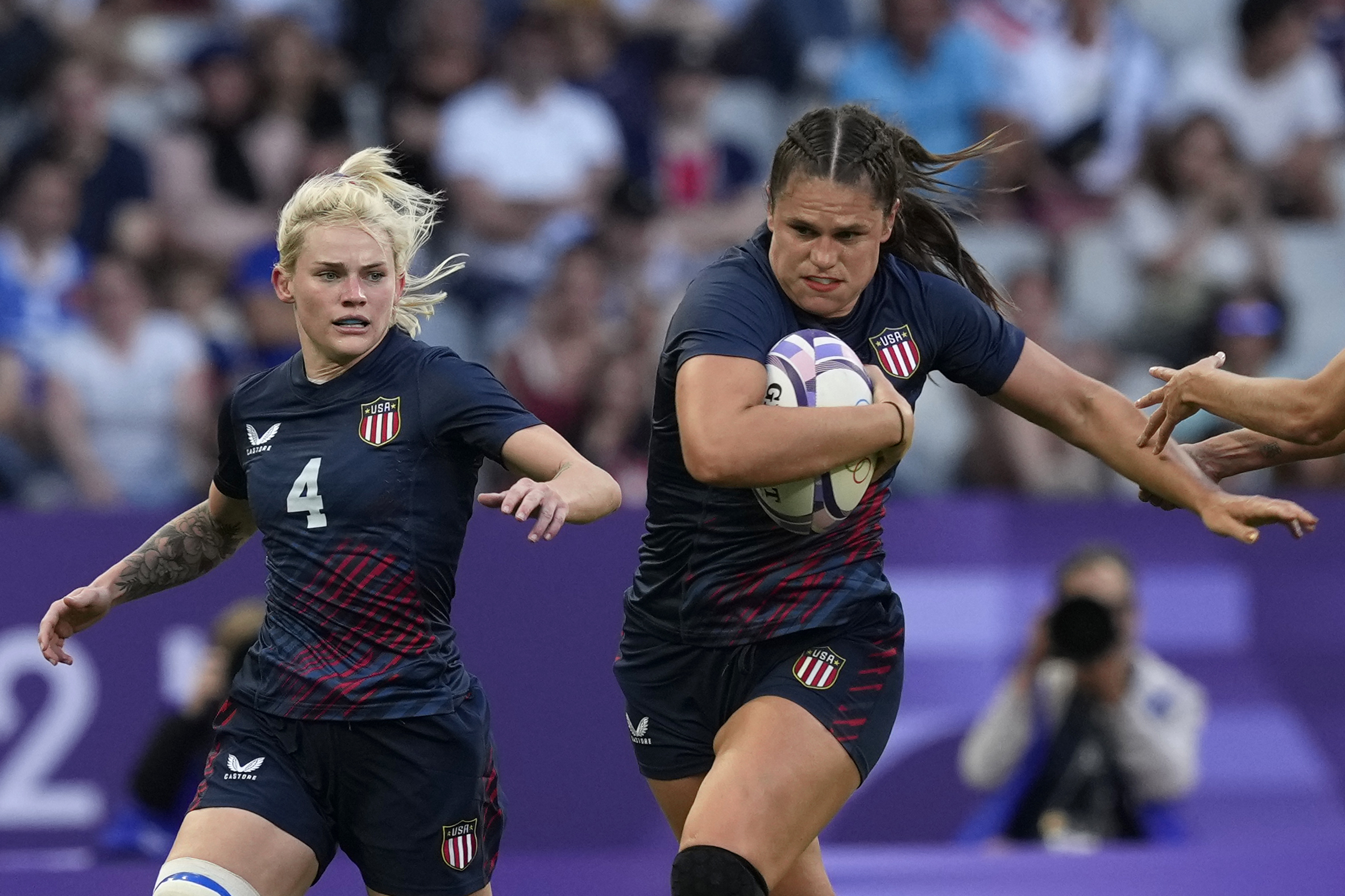 United States' Ilona Maher, fends off the tackle of Brazil's Gabriela Lima, right, during the women's Pool C Rugby Sevens match between the United States and Brazil at the 2024 Summer Olympics, in the Stade de France, in Saint-Denis, France, Sunday, July 28, 2024. 