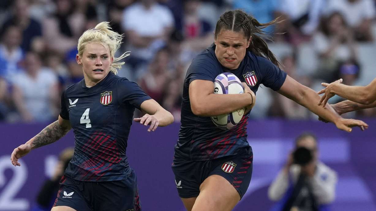 United States' Ilona Maher, fends off the tackle of Brazil's Gabriela Lima, right, during the women's Pool C Rugby Sevens match between the United States and Brazil at the 2024 Summer Olympics, in the Stade de France, in Saint-Denis, France, Sunday, July 28, 2024.