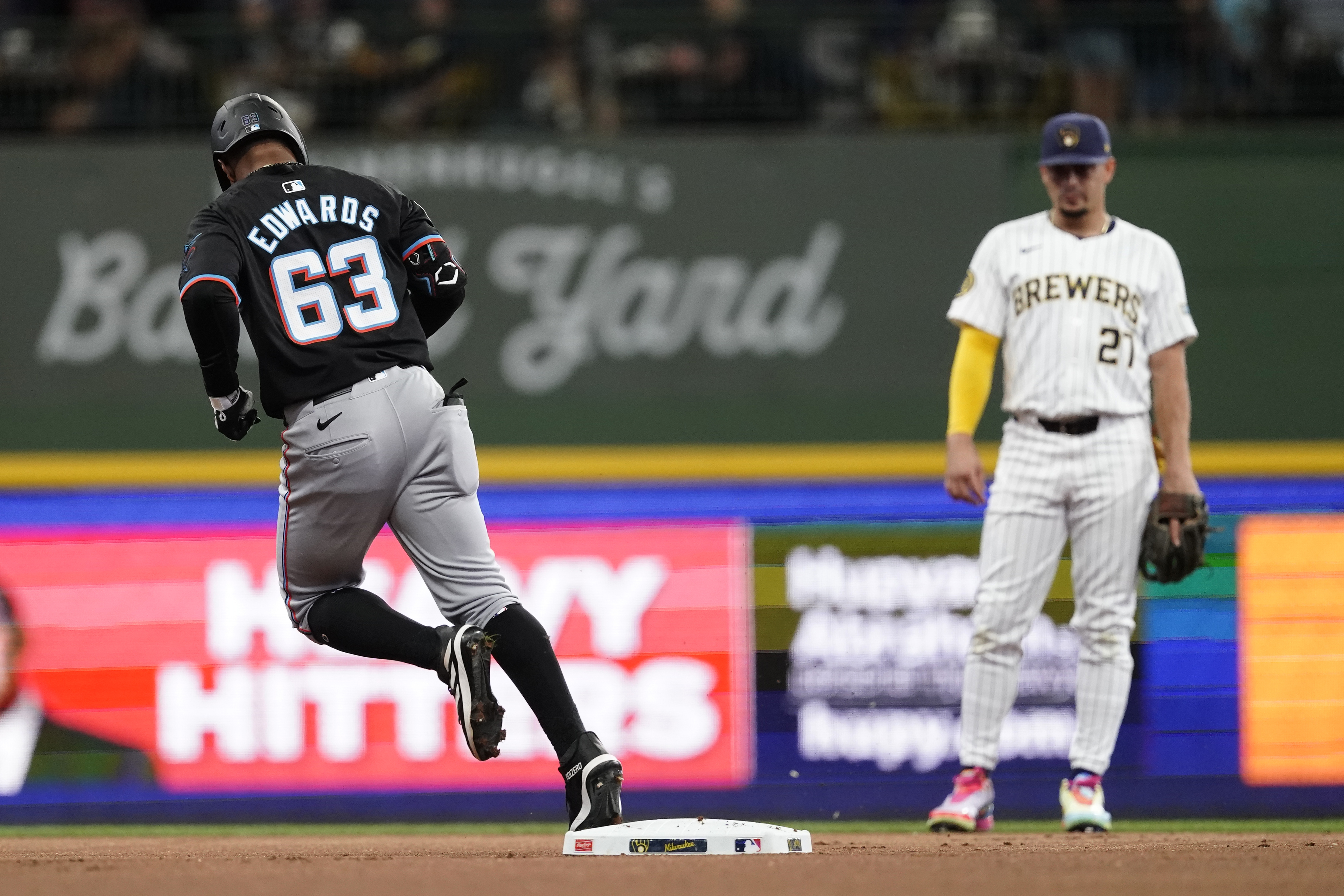 Miami Marlins' Xavier Edwards (63) rounds the bases in front of Milwaukee Brewers' Willy Adames, right, after hitting a solo home run during the first inning of a baseball game Sunday, July 28, 2024, in Milwaukee. 
