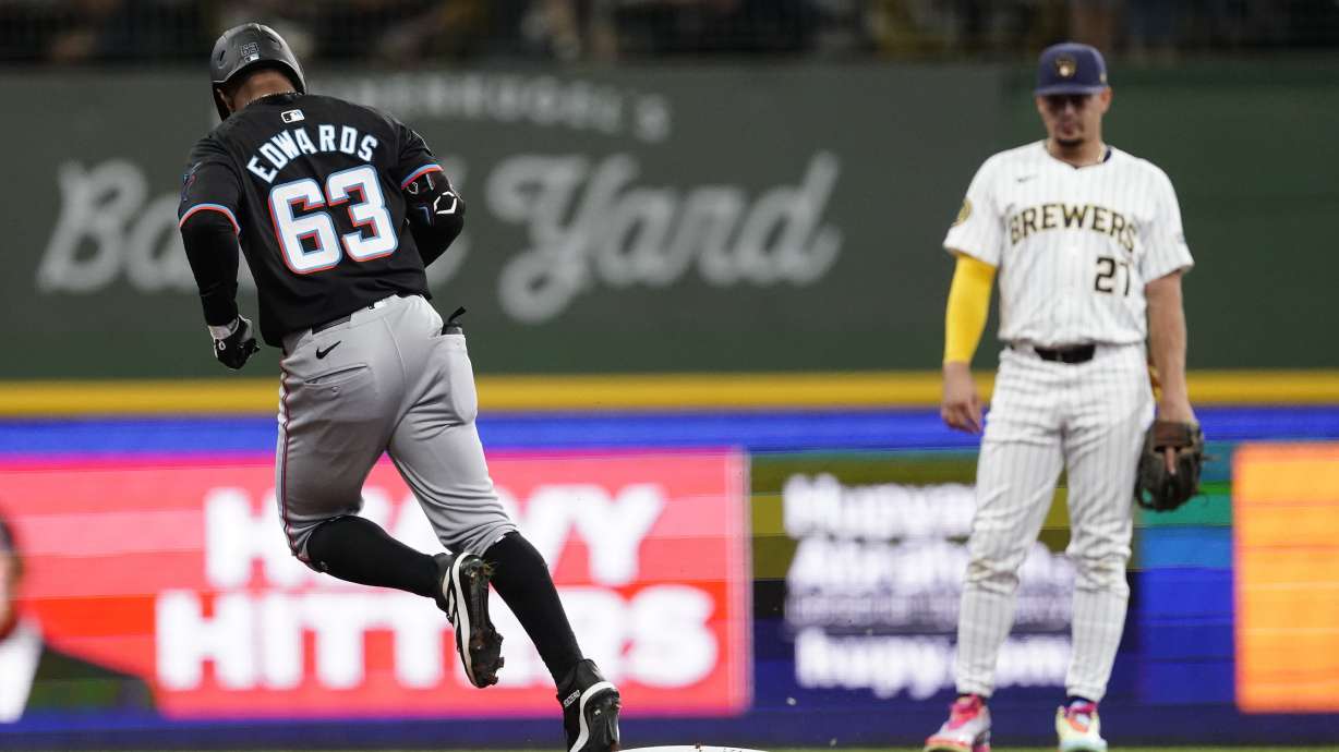 Miami Marlins' Xavier Edwards (63) rounds the bases in front of Milwaukee Brewers' Willy Adames, right, after hitting a solo home run during the first inning of a baseball game Sunday, July 28, 2024, in Milwaukee.
