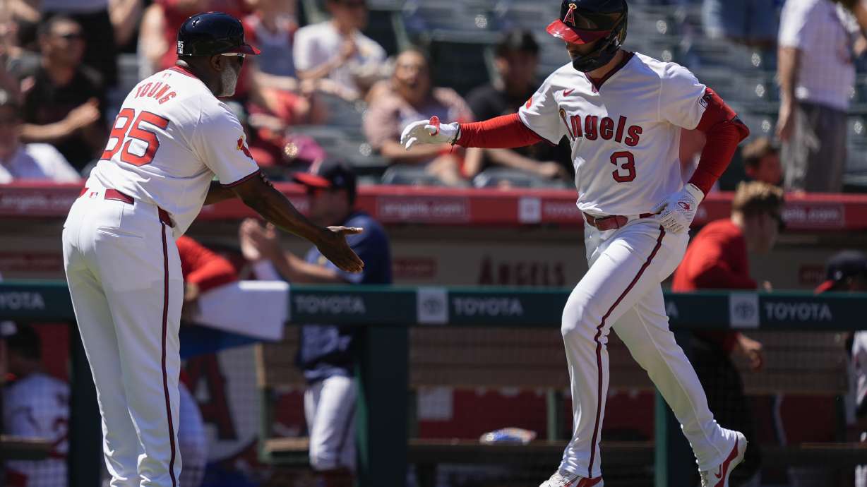 Los Angeles Angels' Taylor Ward (3) celebrates his grand slam with third base coach Eric Young Sr. during the fourth inning of a baseball game against the Oakland Athletics, Sunday, July 28, 2024, in Anaheim, Calif.