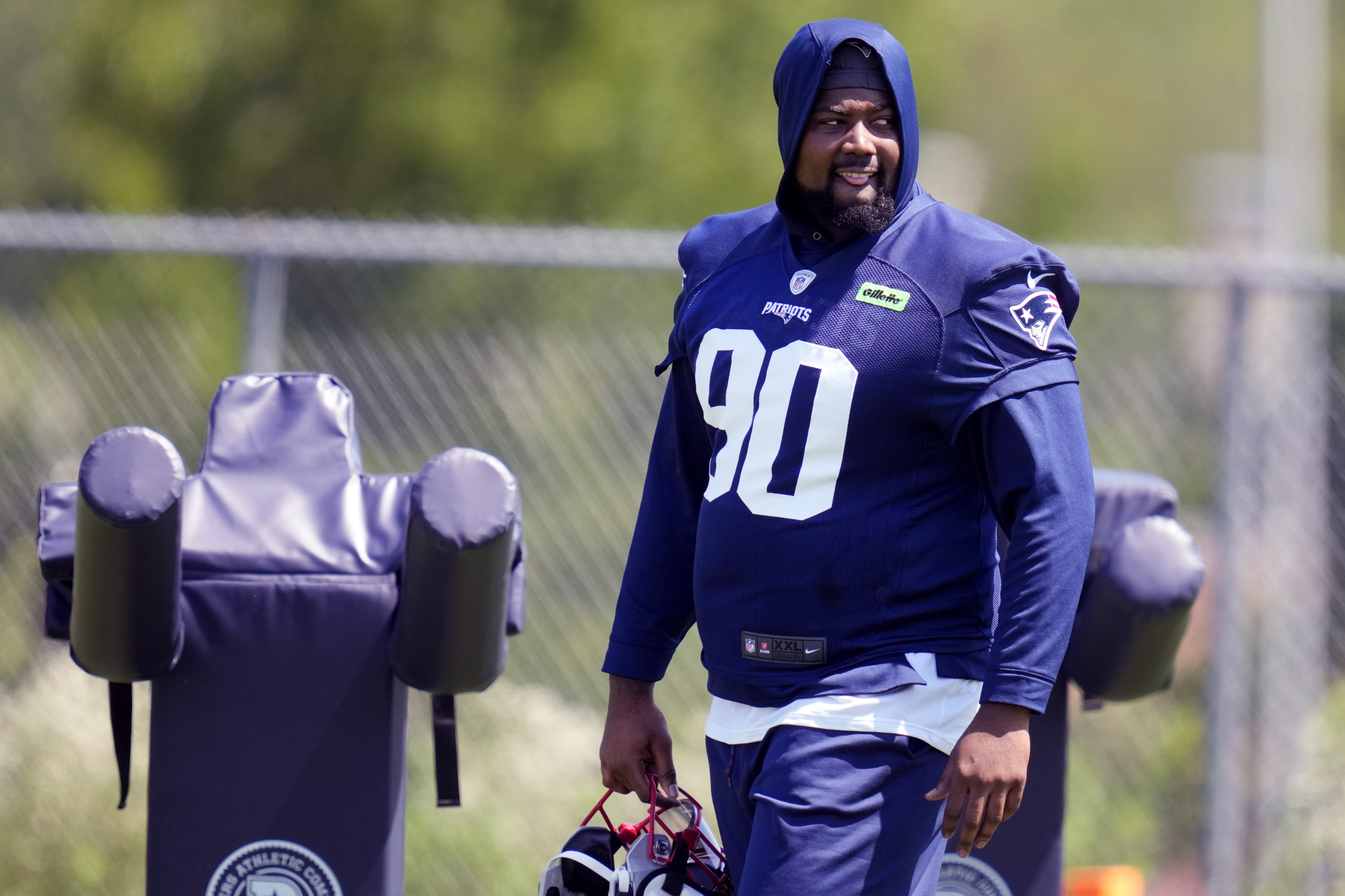 New England Patriots defensive tackle Christian Barmore (90) watches his teammates practice during an NFL football training camp, Friday, July 26, 2024, in Foxborough, Mass.