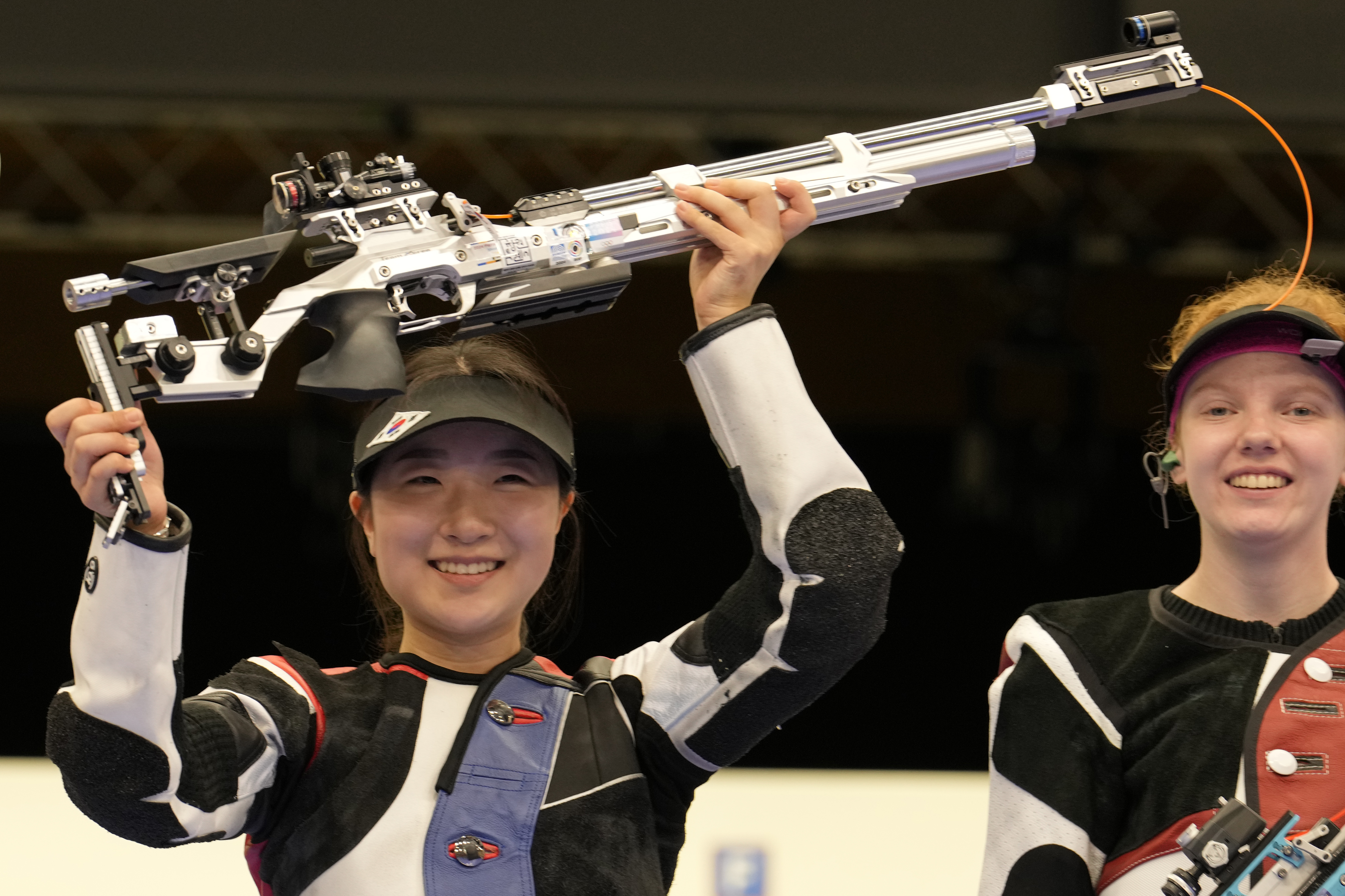 South Korea's Ban Hyojin, left, celebrates after winning the 10m air rifle women's final as the third-place holder Switzerland's Audrey Gogniat looks on at the 2024 Summer Olympics, Monday, July 29, 2024, in Chateauroux, France. 