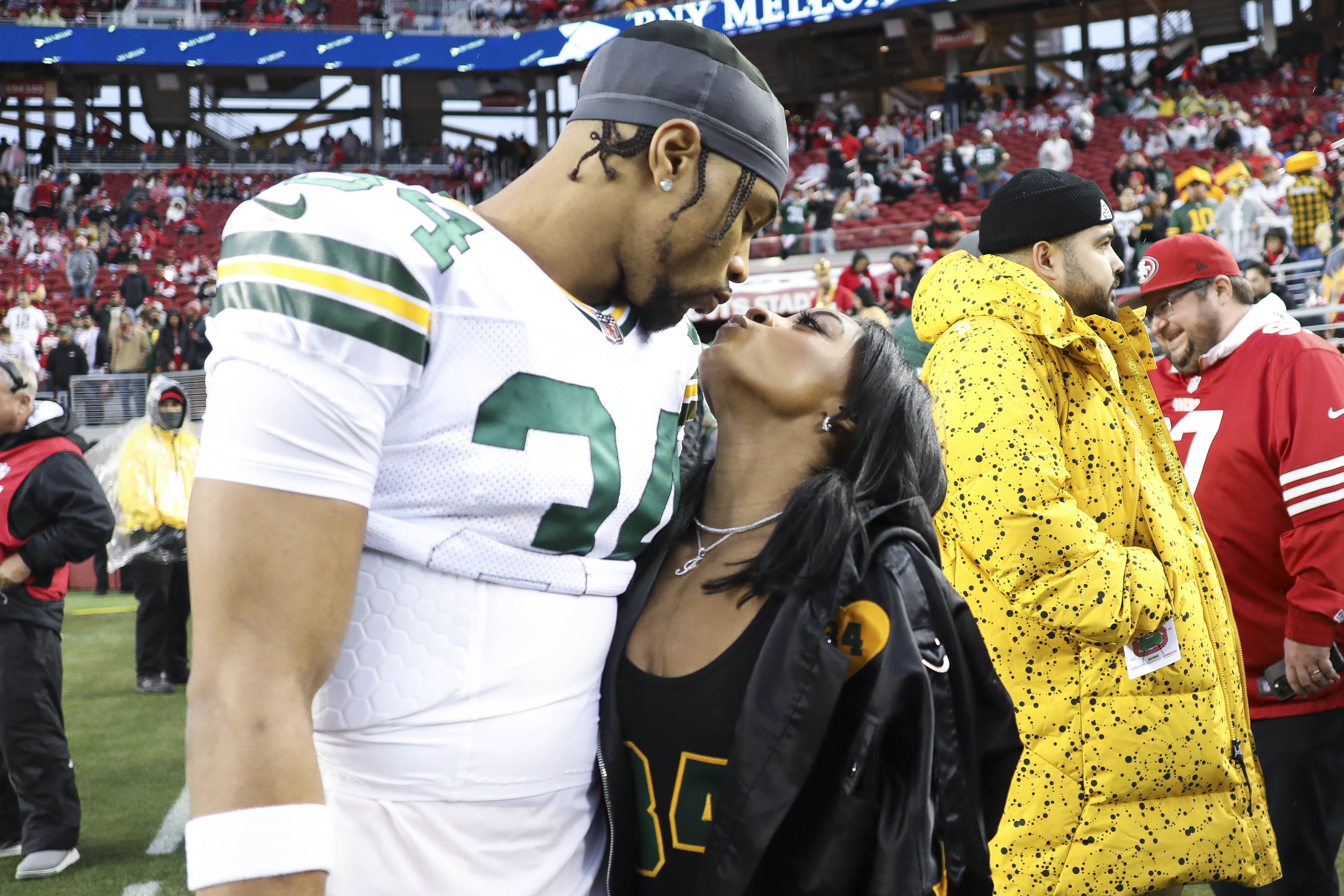FILE - Green Bay Packers safety Jonathan Owens and Simone Biles kiss before an NFL football NFC divisional playoff game between the Packers and the San Francisco 49ers, on Jan. 20, 2024, in Santa Clara, Calif. Owens is taking a break from Chicago Bears training camp to come watch Biles at the Olympic women's gymnastics team final. Owens has been the target of criticism from some Biles' fans for comments he's made about their relationship 