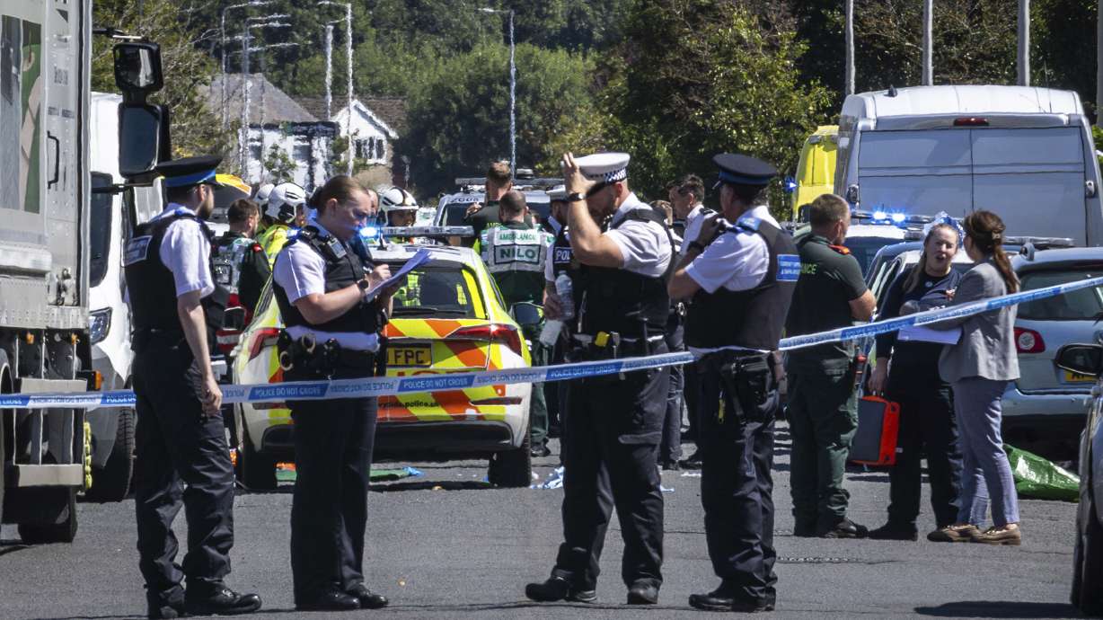Police secure the area where a man has been detained and a knife has been seized after a number of people were injured in a reported stabbing, in Southport, Merseyside, England, Monday.