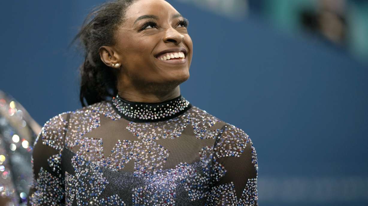 Simone Biles of United States, smiles after competing on the uneven bars during a women's artistic gymnastics qualification round at Bercy Arena at the 2024 Summer Olympics, Sunday, July 28, 2024, in Paris, France.
