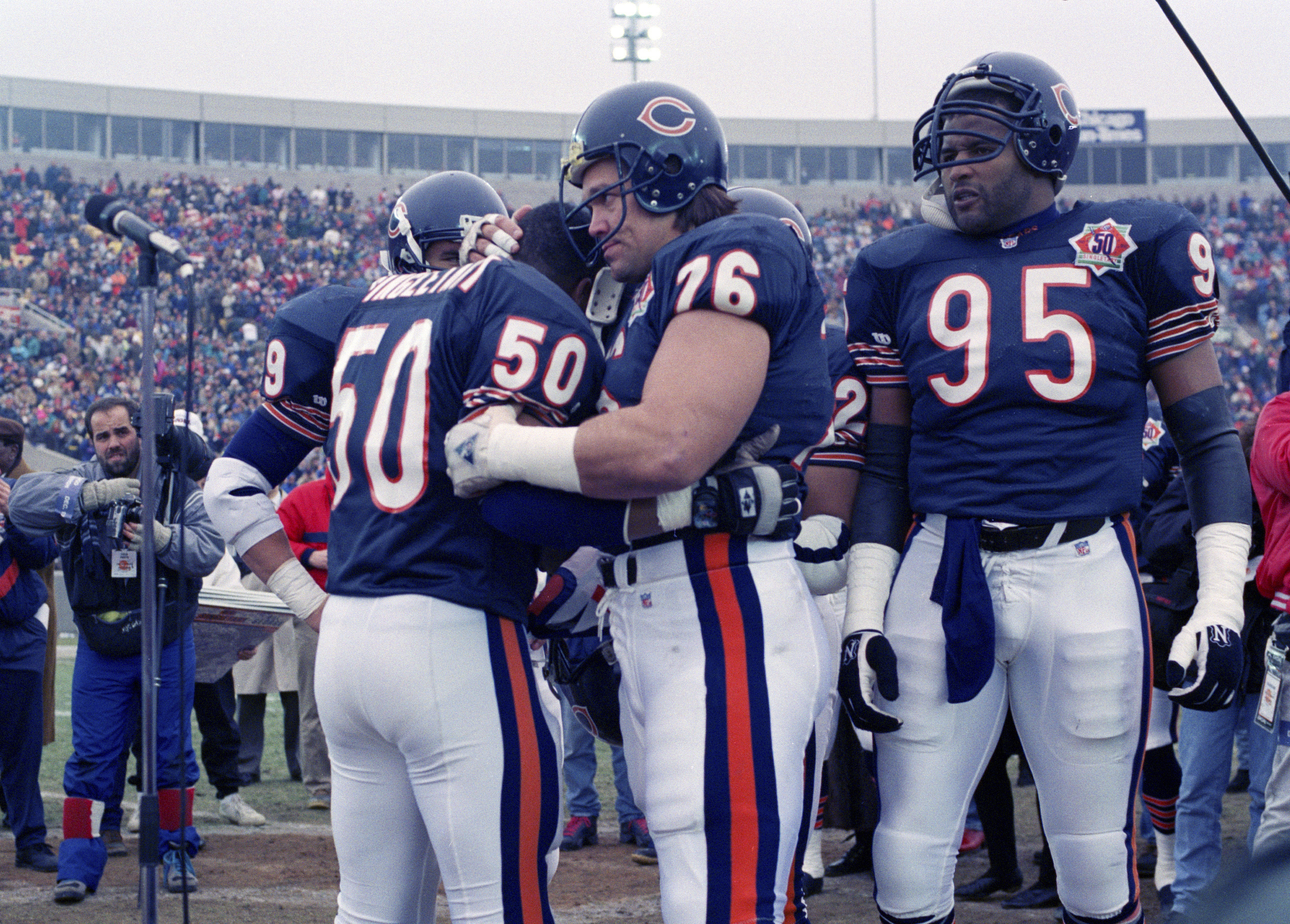 FILE - Chicago Bears nine-time Pro Bowler Mike Singletary (50) gets a bear hug from teammate Steve McMichael (76) prior to an NFL football game against the Pittsburgh Steelers in Chicago, Dec. 13, 1992. McMichael will be inducted into the Pro Football Hall of Fame Saturday, Aug. 3, 2024.
