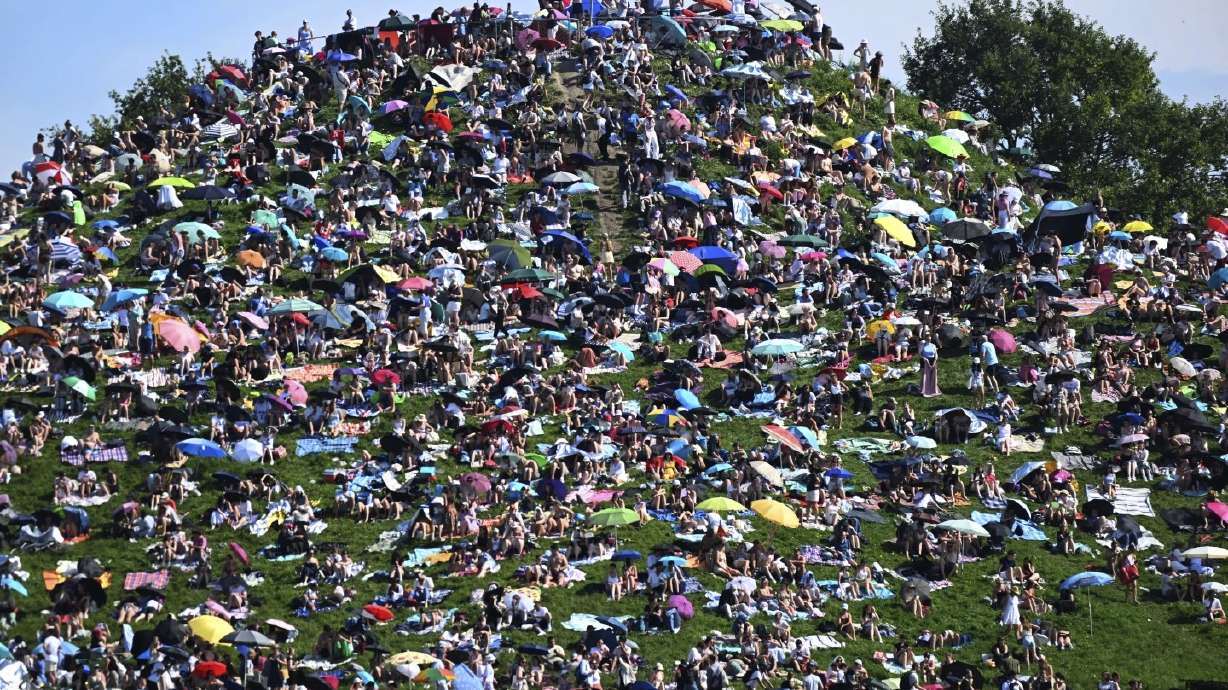Fans sit on Olympic Hill in Munich, Germany, on July 28 to see Taylor Swift perform for free. Police estimate up to 25,000 people camped out on the hill.