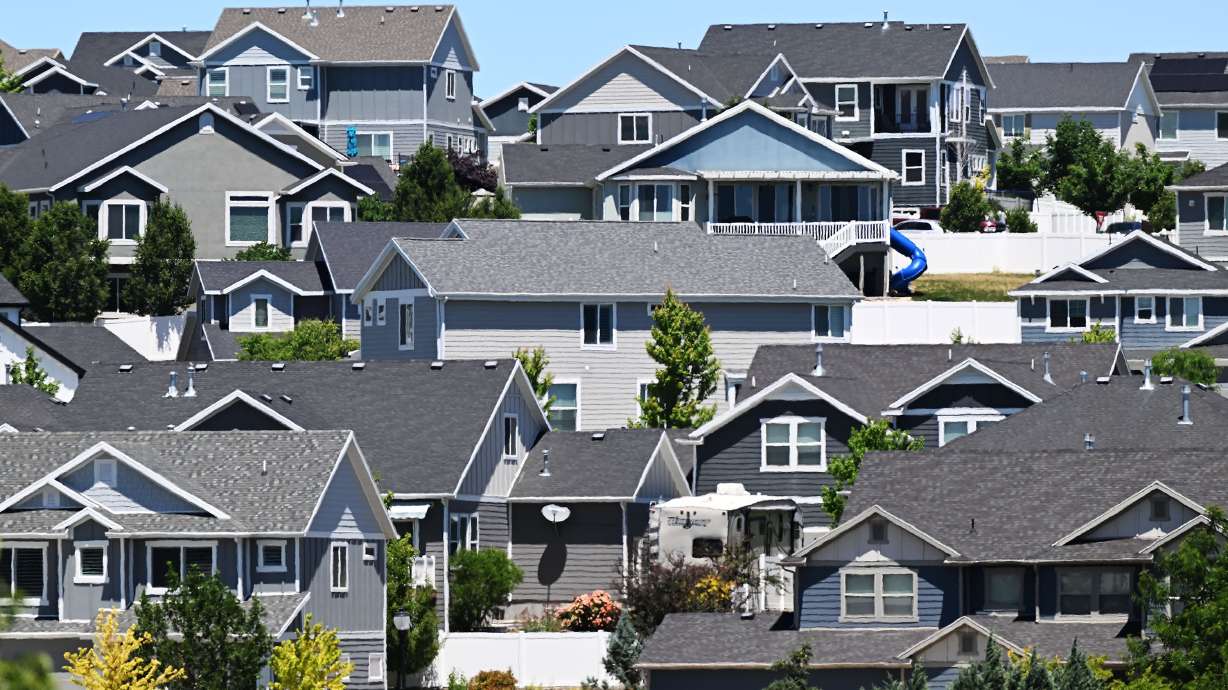 Homes and "for sale" signs are pictured in the Salt Lake Valley on June 18. According to real estate company Redfin, monthly housing payments are at their lowest in four months.