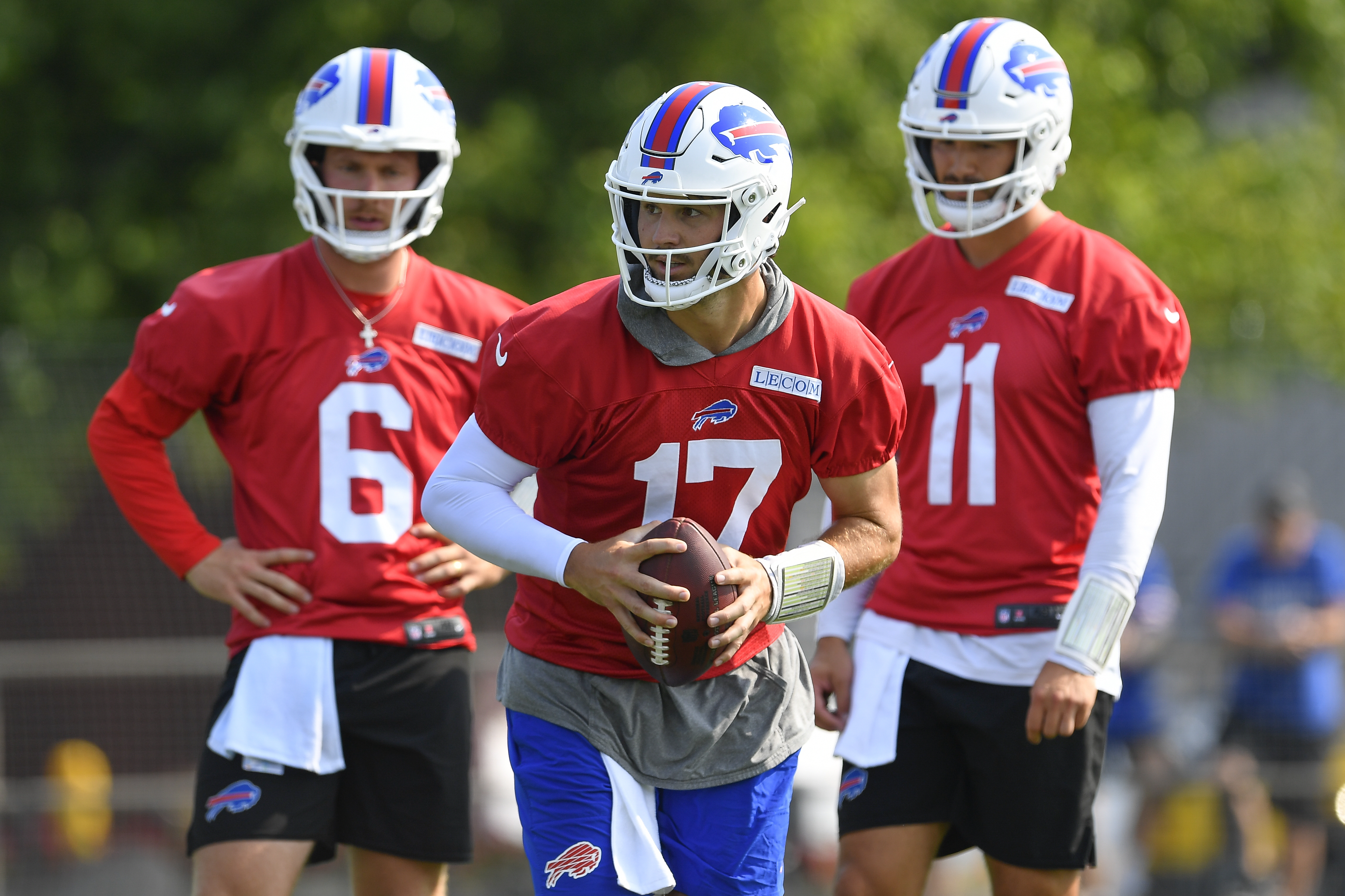 Buffalo Bills quarterback Josh Allen (17) runs a drill as quarterbacks Shane Buechele (6) and Mitchell Trubisky (11) look on during an NFL football training camp practice in Pittsford, N.Y., Sunday, July 28, 2024. 