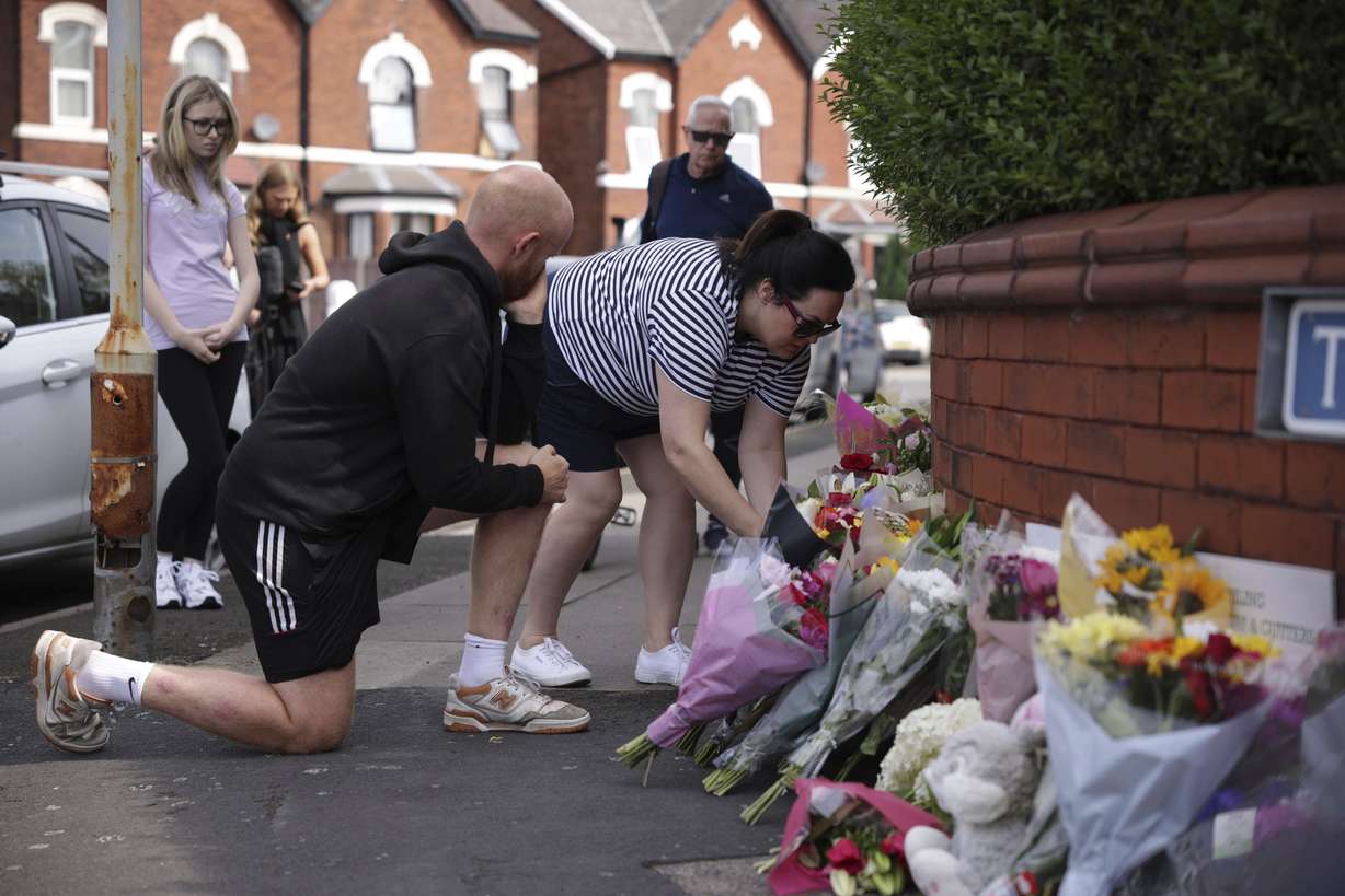 People leave flowers near the scene in Hart Street where children died and were injured in a knife attack during a Taylor Swift event at a dance school on Monday, in Southport, England, Tuesday.