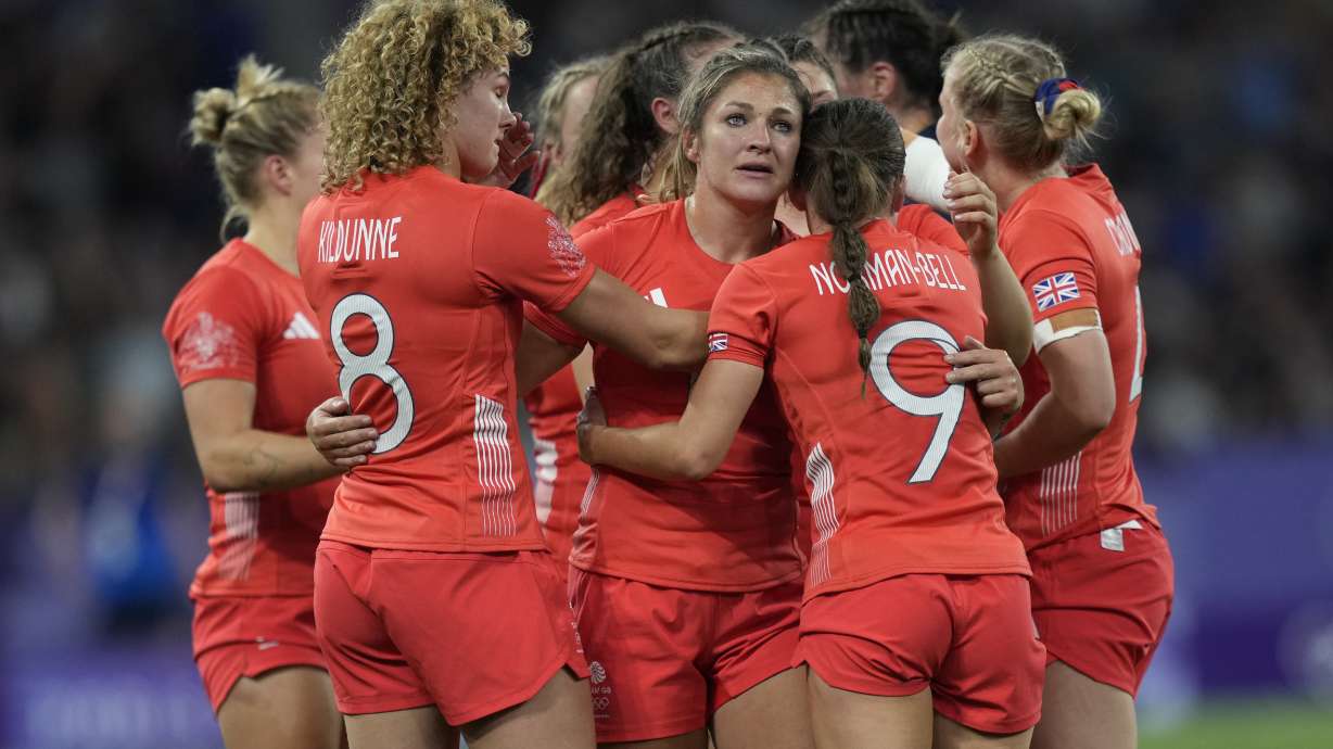 Great Britain's Amy Wilson Hardy, center joins her teammates in a huddle after they lost their women's quarterfinal Rugby Sevens match between Great Britain and the United States at the 2024 Summer Olympics, in the Stade de France, in Saint-Denis, France, Monday, July 29, 2024. The US won the game 17-7.