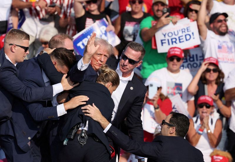 Republican presidential candidate and former president Donald Trump stands with a bloodied face after he was shot in the right ear during a campaign rally at the Butler Farm Show in Butler, Pa., July 13.