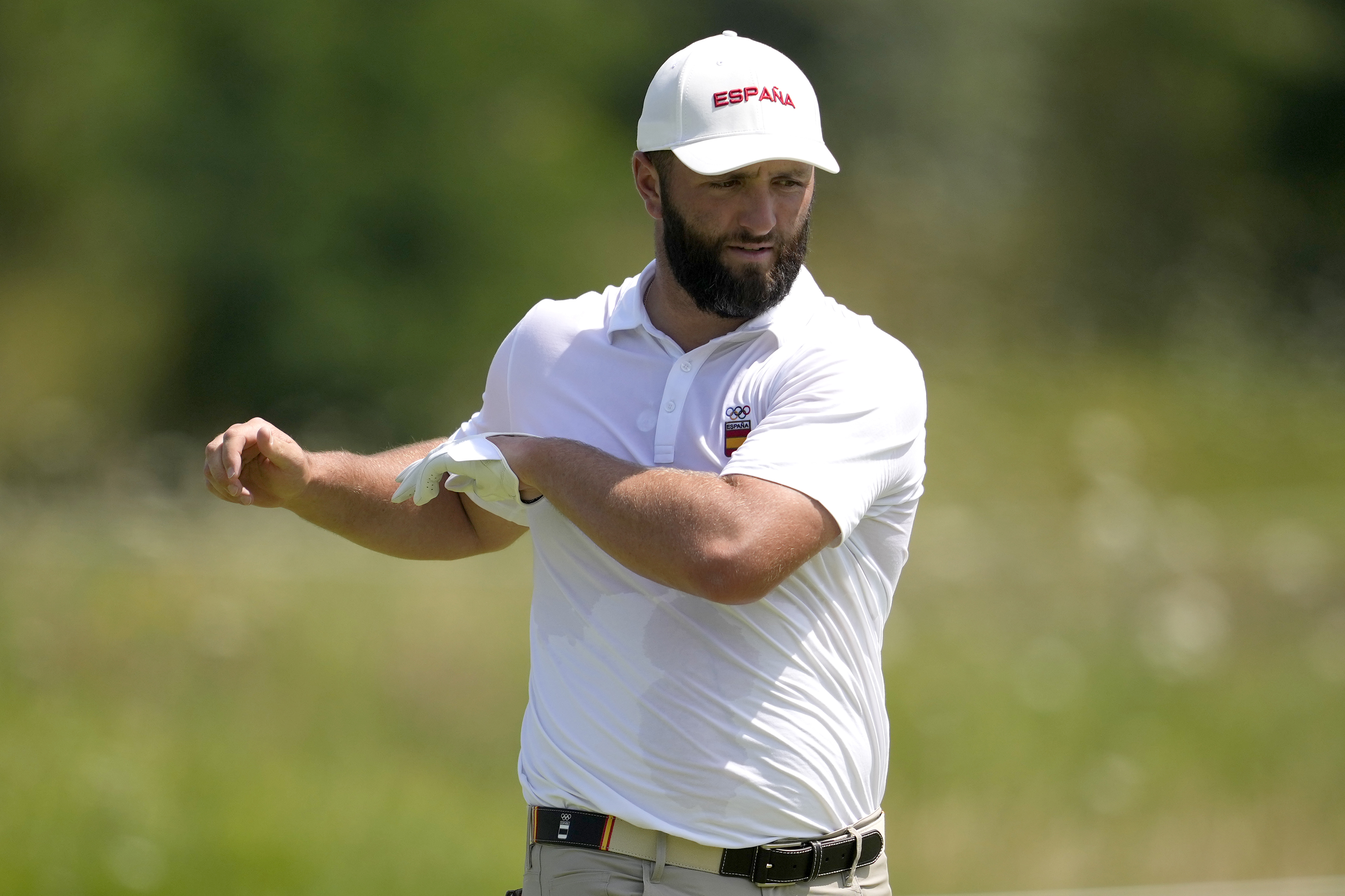 Jon Rahm, of Spain, stretches on the sixth green during a practice round for the men's golf event at the 2024 Summer Olympics, Tuesday, July 30, 2024, at Le Golf National in Saint-Quentin-en-Yvelines, France. 