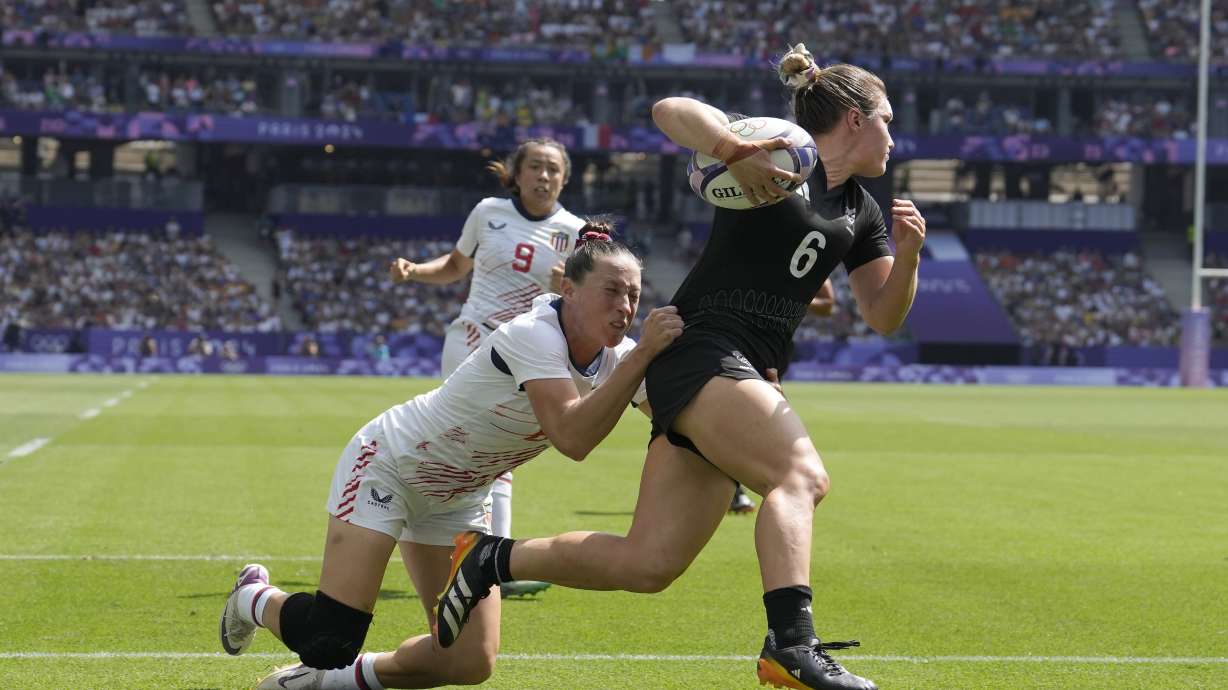 New Zealand's Michaela Blyde, right, scores a try despite a tackle by United States' Lauren Doyle during the women's semifinal Rugby Sevens match between New Zealand and the United States at the 2024 Summer Olympics, in the Stade de France, in Saint-Denis, France, Tuesday, July 30, 2024.