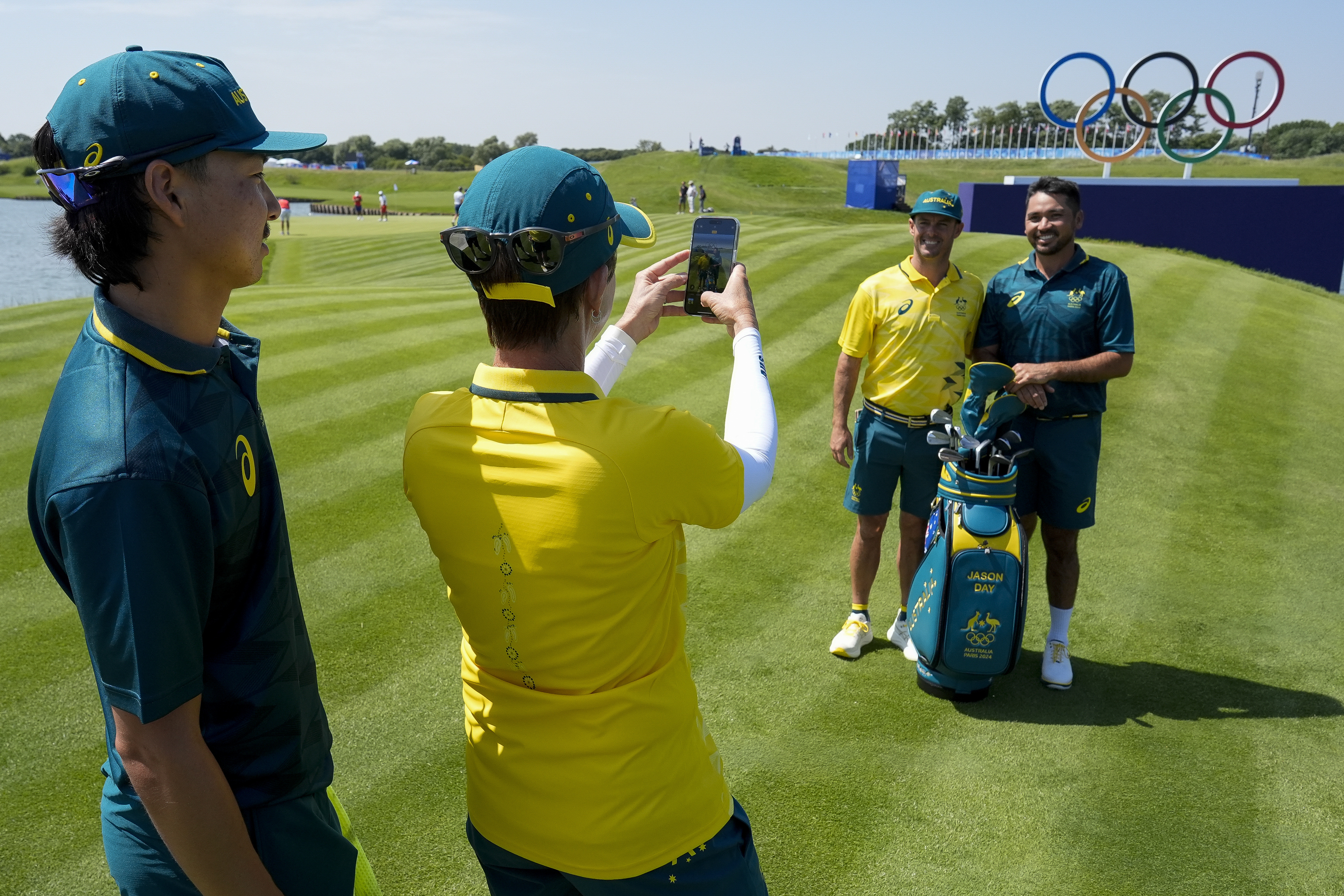 Jason Day, of Australia, right, poses with his caddie Luke Reardon after a practice round for the men's golf event at the 2024 Summer Olympics, as teammate Min Woo Lee, left, looks on Monday, July 29, 2024, at Le Golf National in Saint-Quentin-en-Yvelines, France.