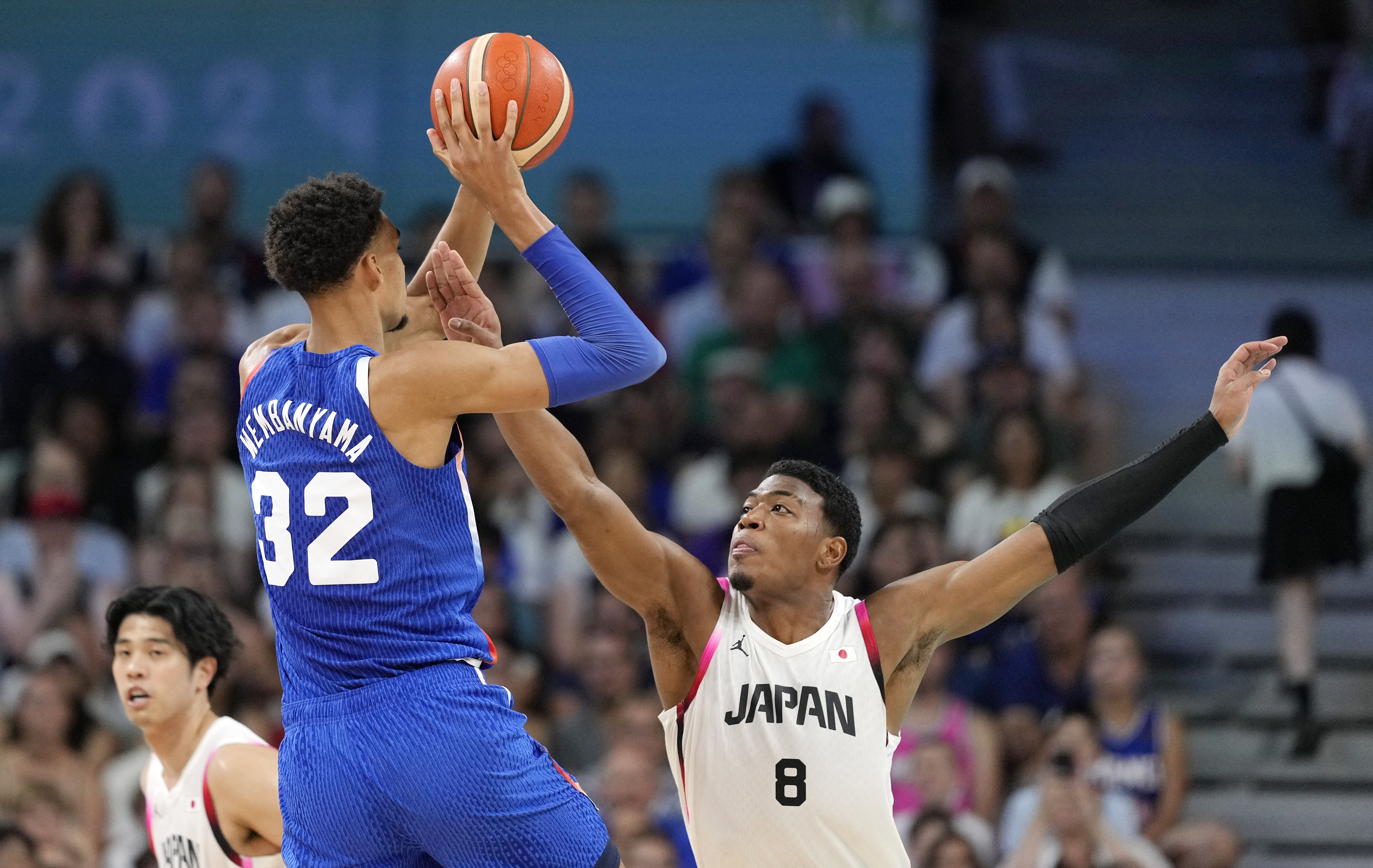 France's Victor Wembanyama, center, shoots as Japan's Rui Hachimura, right, defends in a men's basketball game at the 2024 Summer Olympics, Tuesday, July 30, 2024, in Villeneuve-d'Ascq, France. 