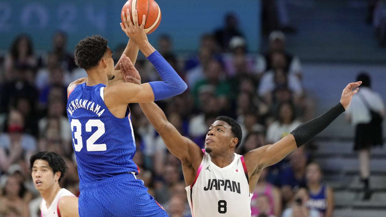France's Victor Wembanyama, center, shoots as Japan's Rui Hachimura, right, defends in a men's basketball game at the 2024 Summer Olympics, Tuesday, July 30, 2024, in Villeneuve-d'Ascq, France.