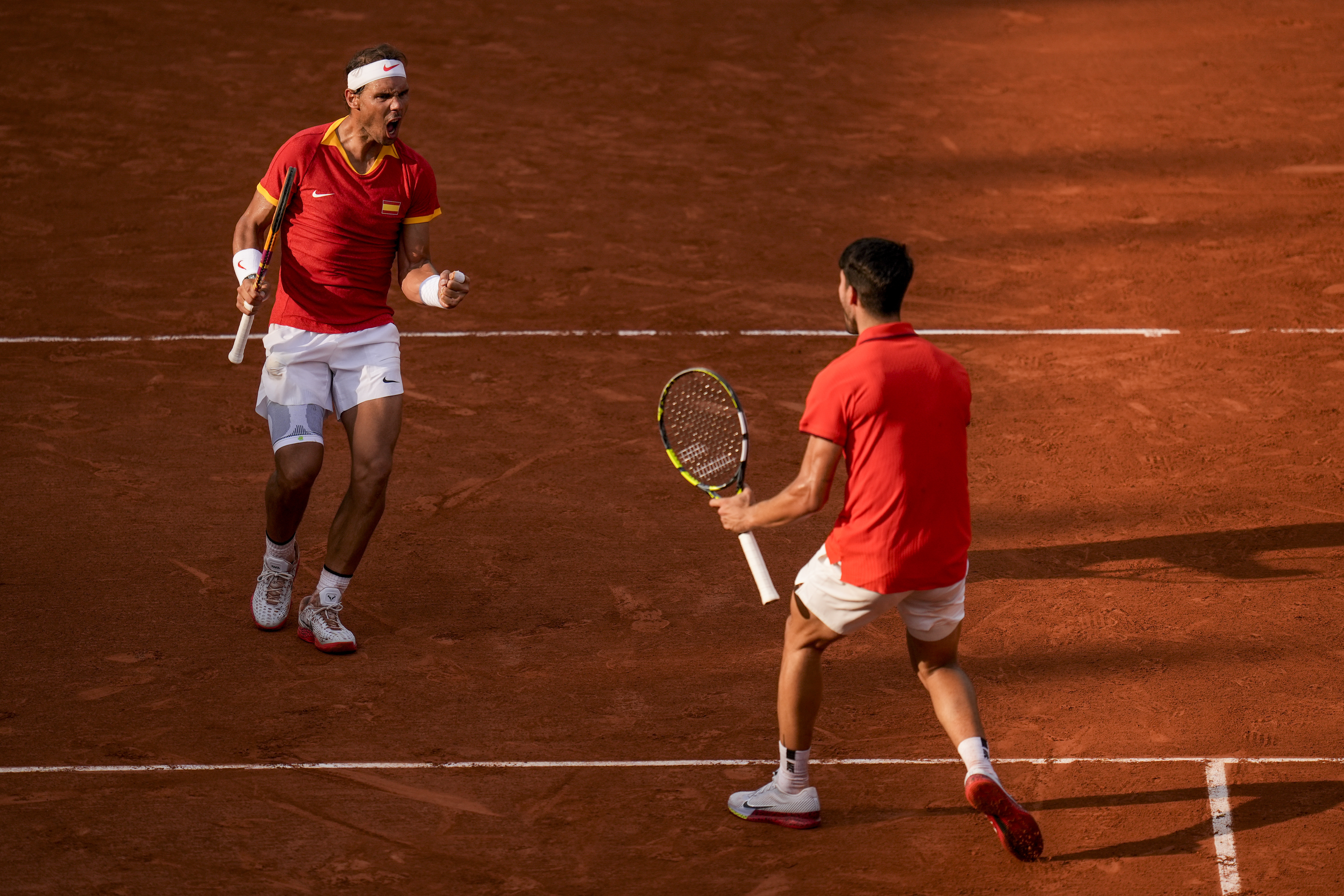 Carlos Alcaraz, right, and Rafael Nadal of Spain celebrate a point against Tallon Griekspoor and Wesley Koolhof of the Netherlands during the men's doubles tennis competition at the Roland Garros stadium, at the 2024 Summer Olympics, Tuesday, July 30, 2024, in Paris, France.